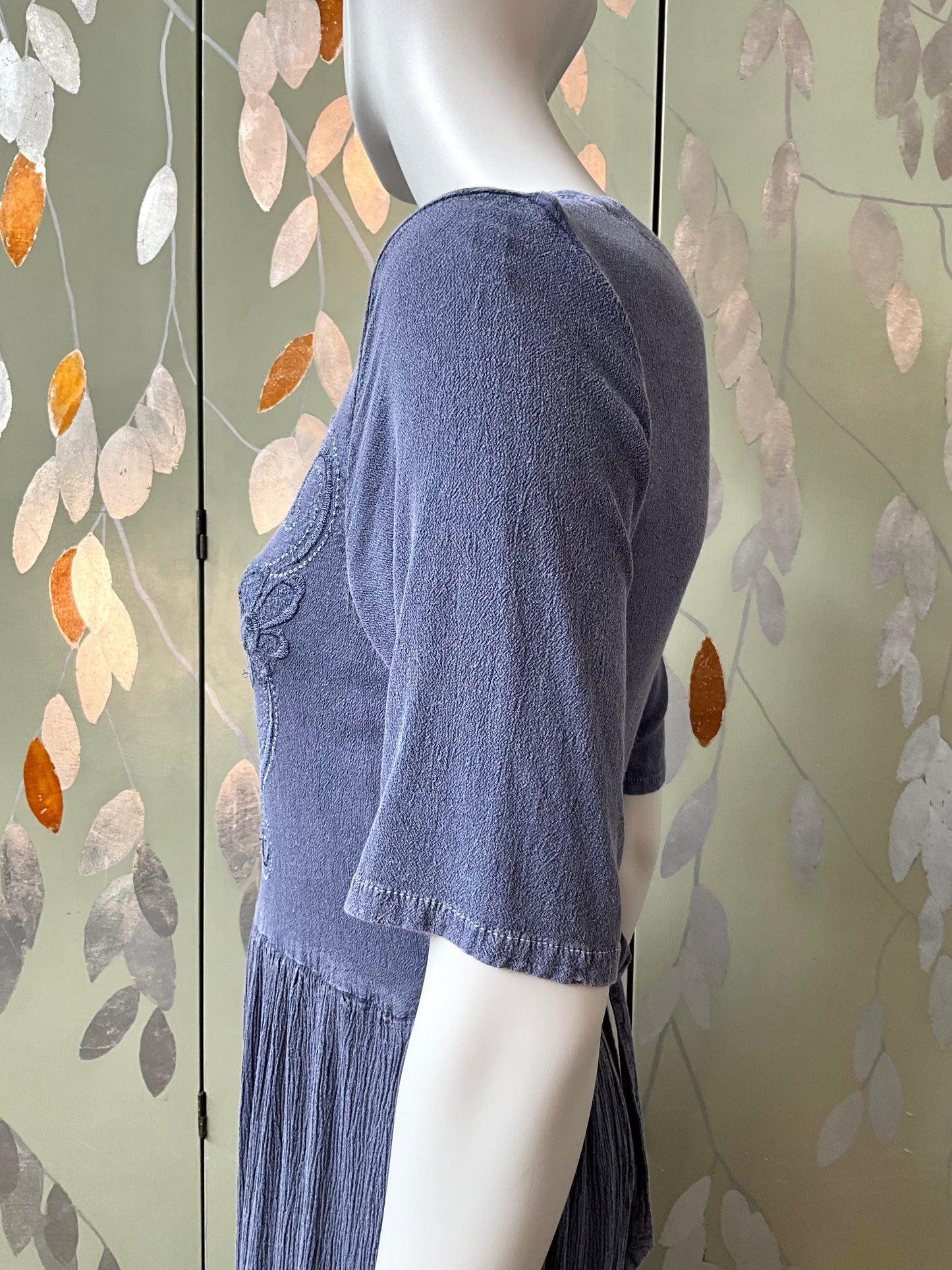 Mannequin wearing a blue dress with a floral background