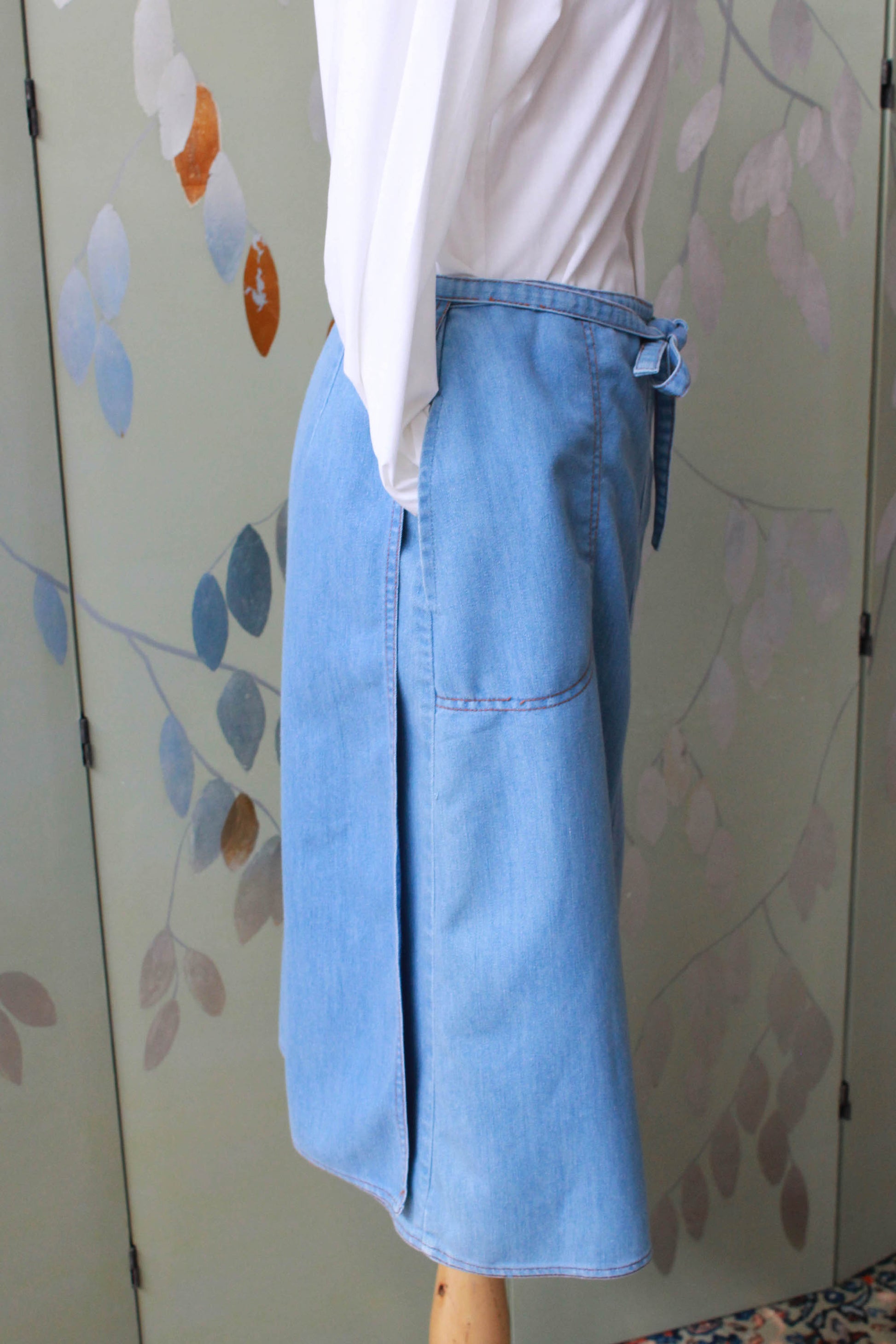 90s vintage chambray light blue jean wrap skirt with waist tie, side pockets, a-line silhouette