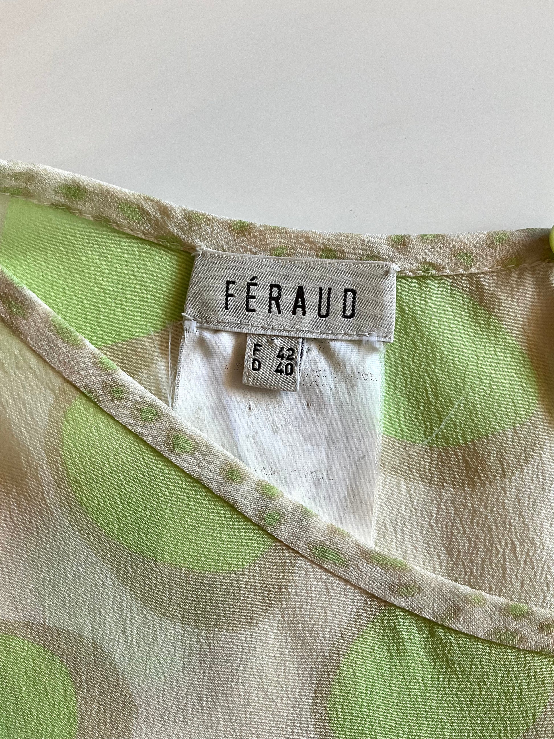 Close-up of a green and beige patterned fabric with a Féraud label.
