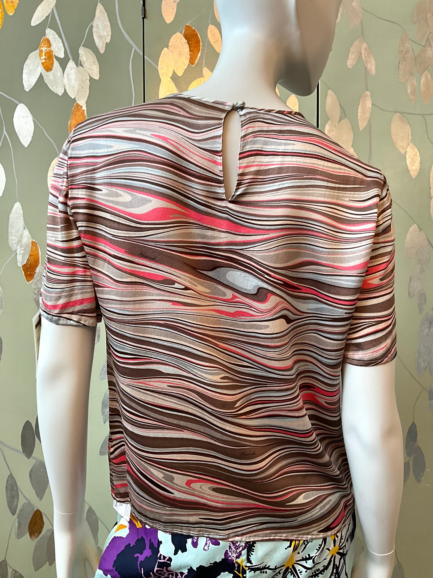 Mannequin wearing a patterned shirt with a decorative background