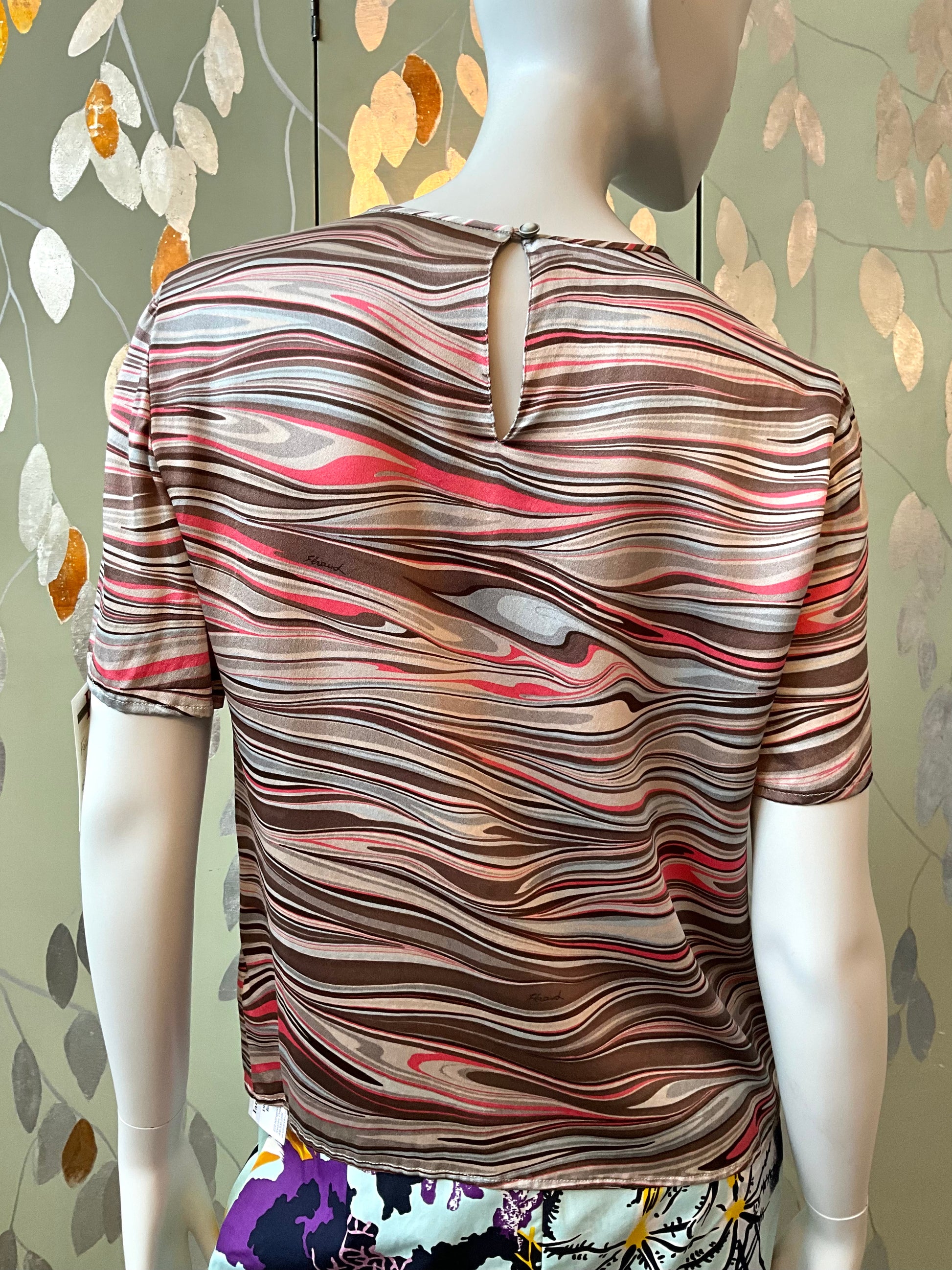 Mannequin wearing a patterned shirt with a decorative background