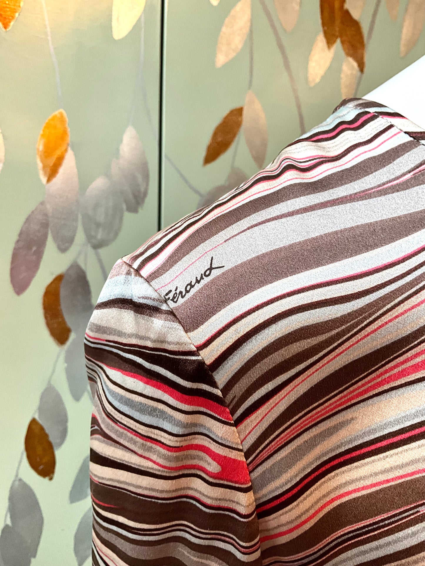 Striped shirt with a brand name on a patterned background