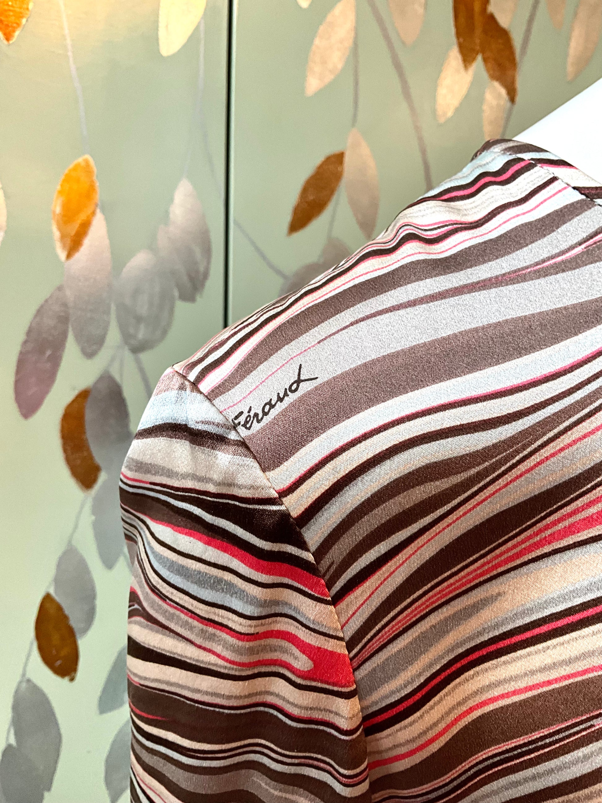 Striped shirt with a brand name on a patterned background