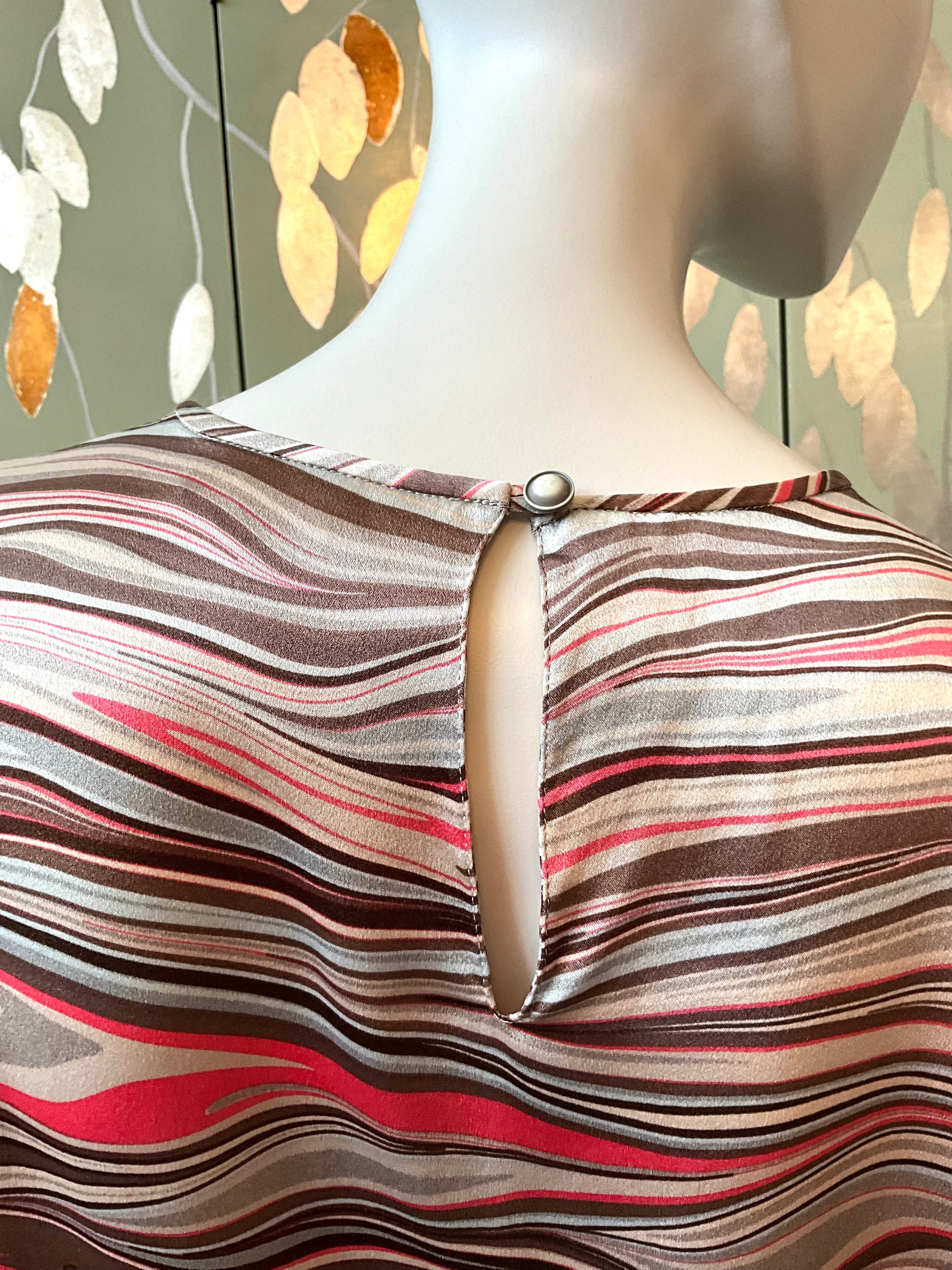 Mannequin wearing a striped top with a floral background