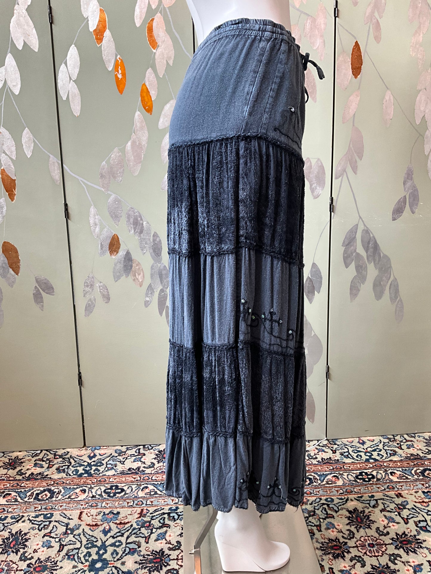 Long layered skirt with a floral patterned wall and rug in the background