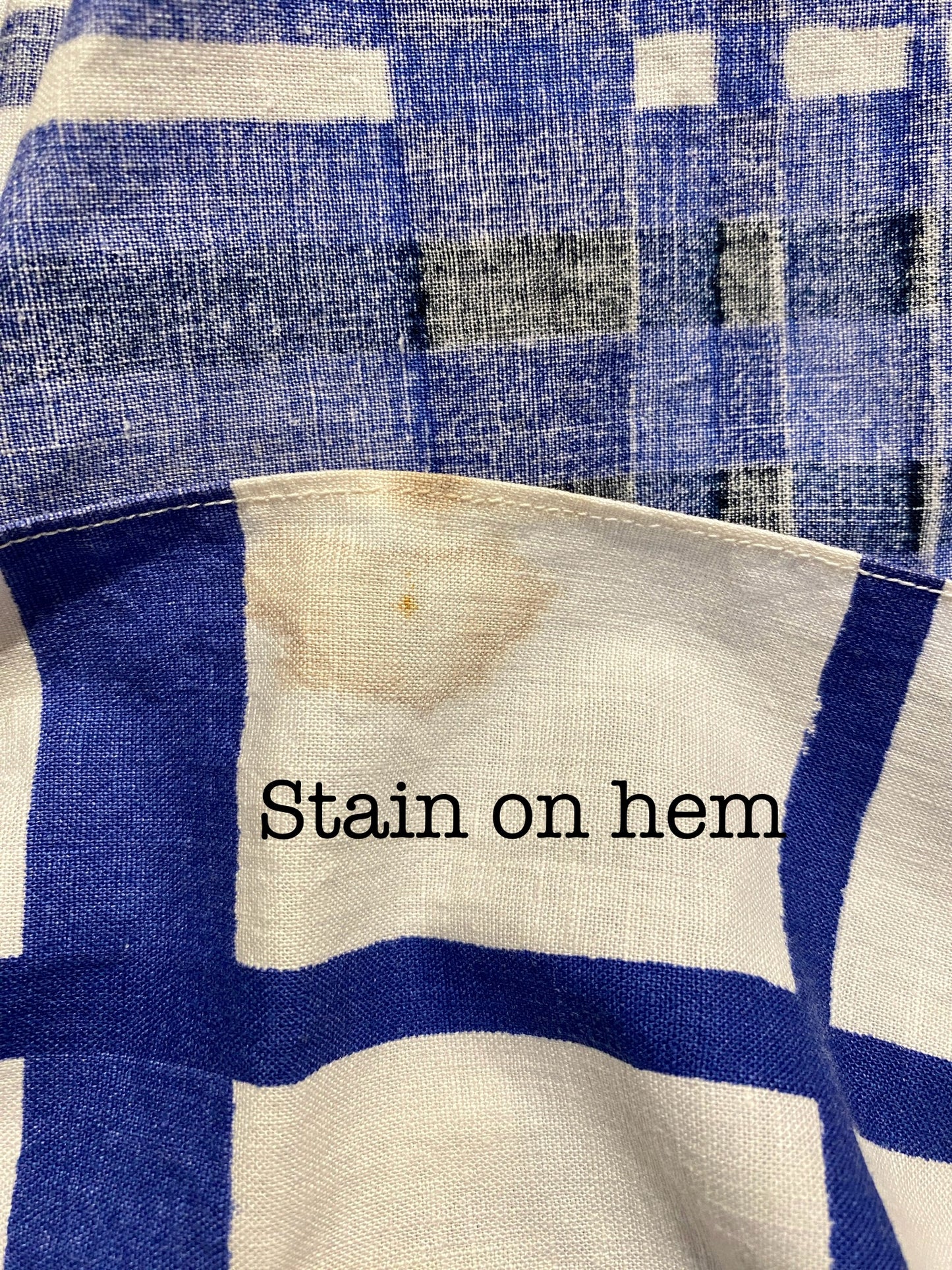 Blue and white checkered skirt with a stain on the hem