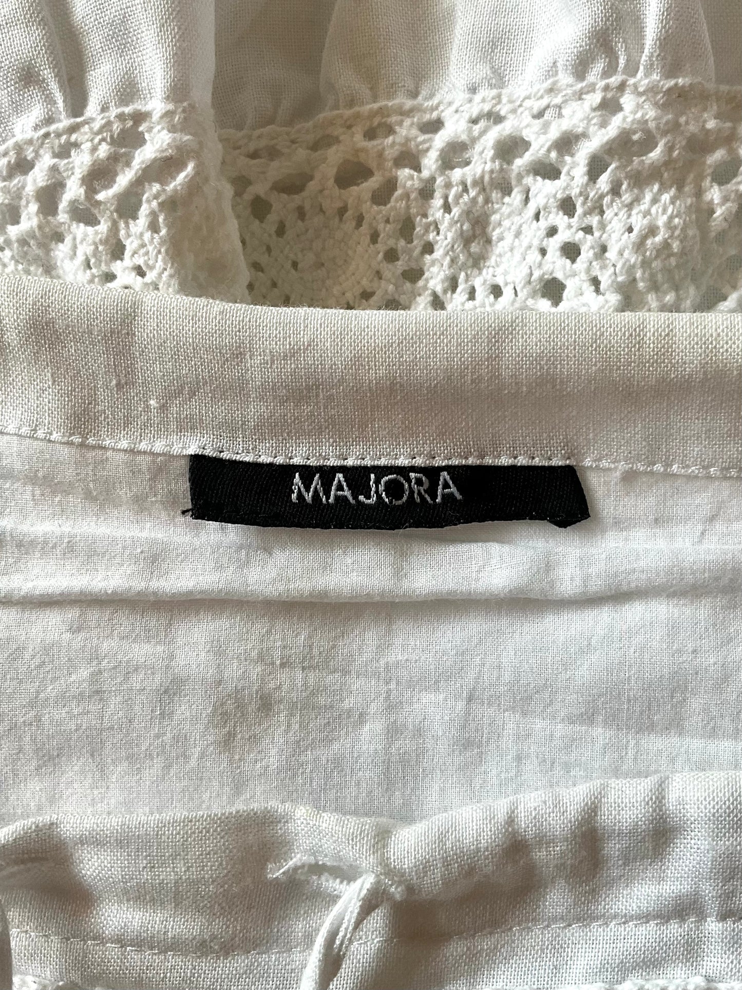 Close-up of a white fabric with a 'MAJORA' label.