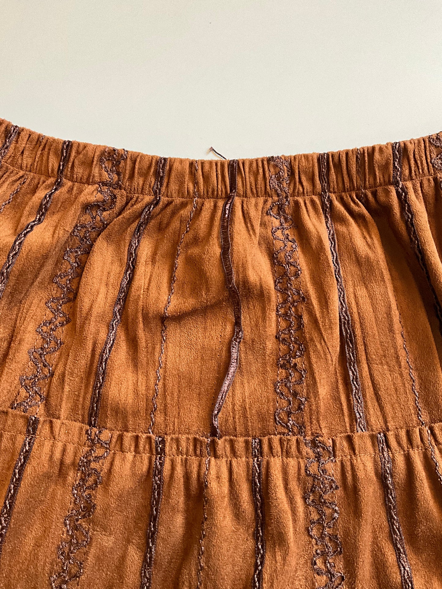 Brown skirt with lace trim on a beige background