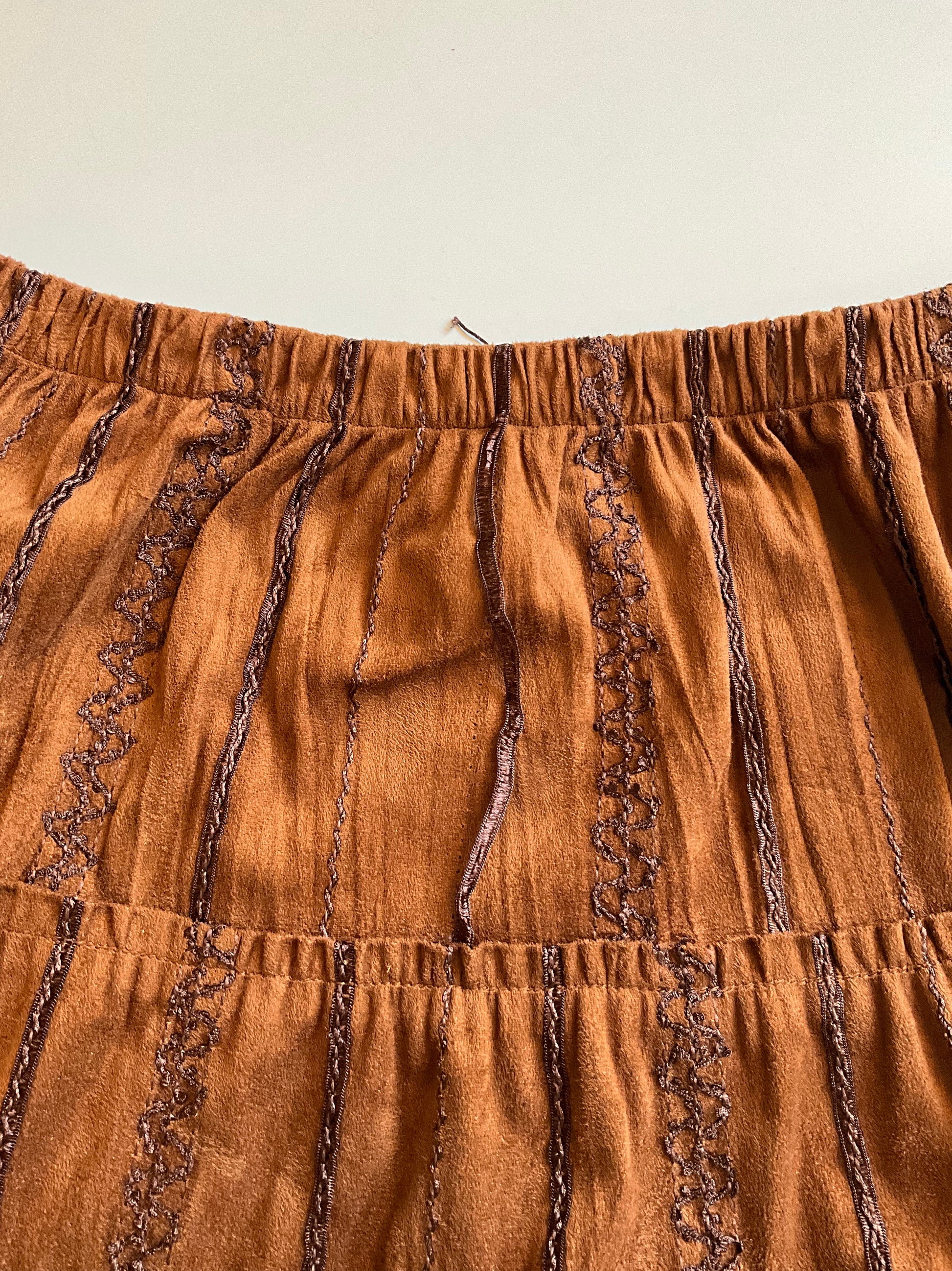 Brown skirt with lace trim on a beige background