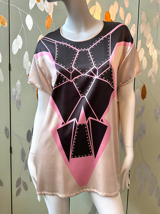 Mannequin wearing a shirt with geometric black and pink design on a leaf-patterned background
