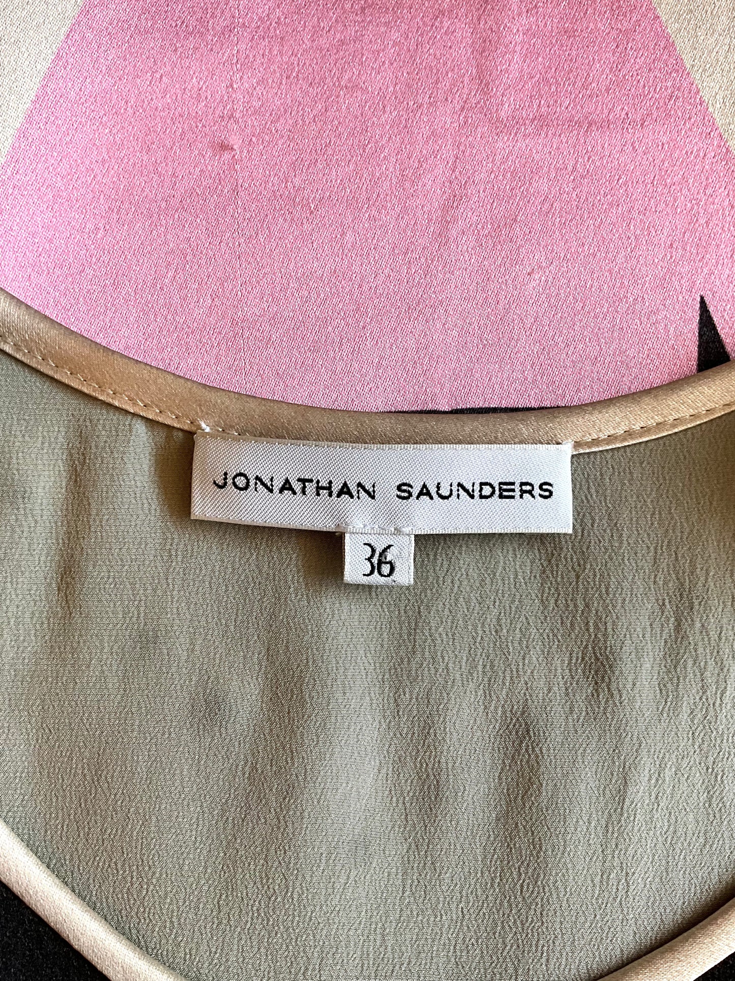 Close-up of a pink and beige garment with a 'Jonathan Saunders' label.