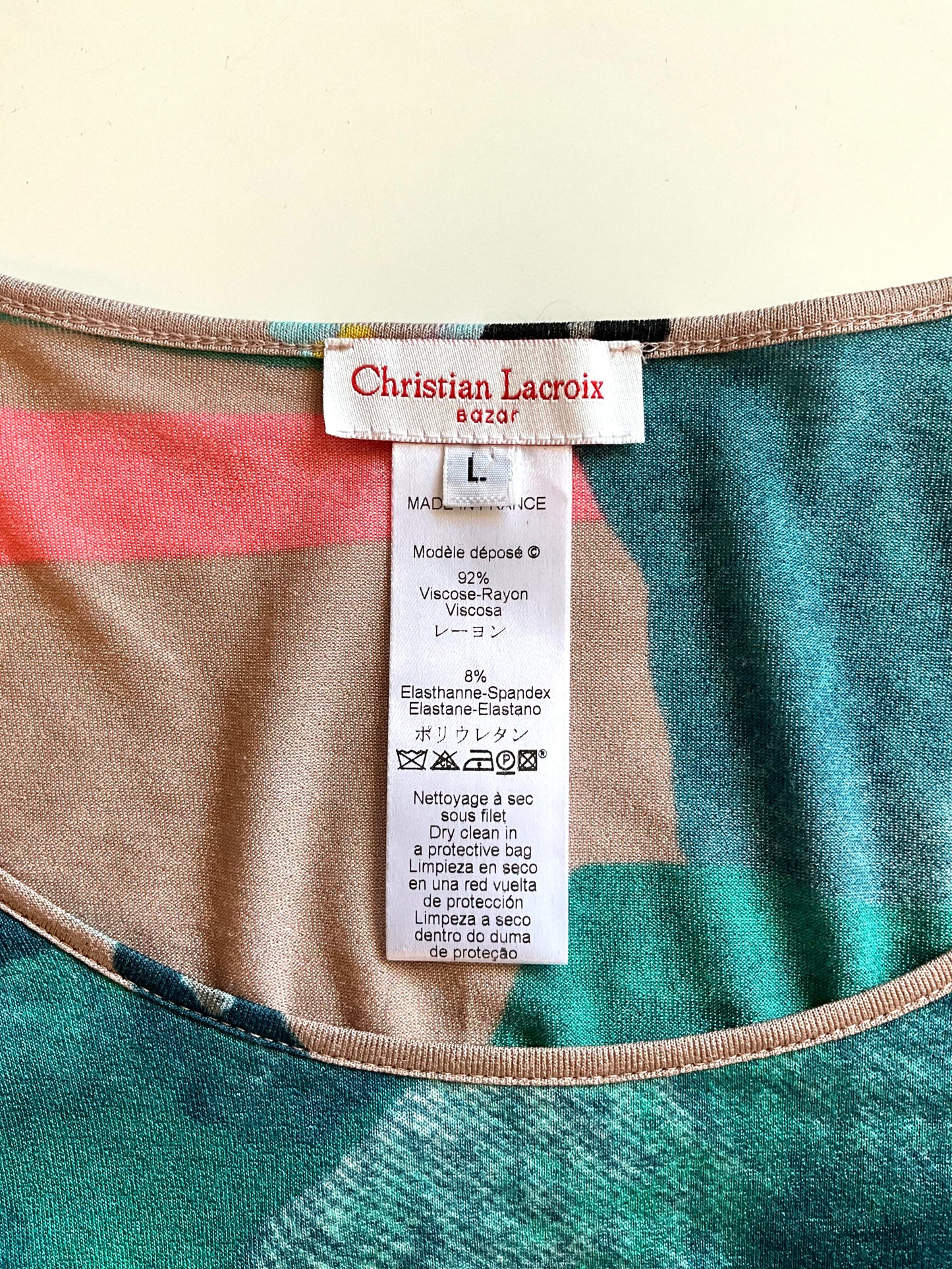 Close-up of a Christian Lacroix label on a garment with a multicolored pattern.