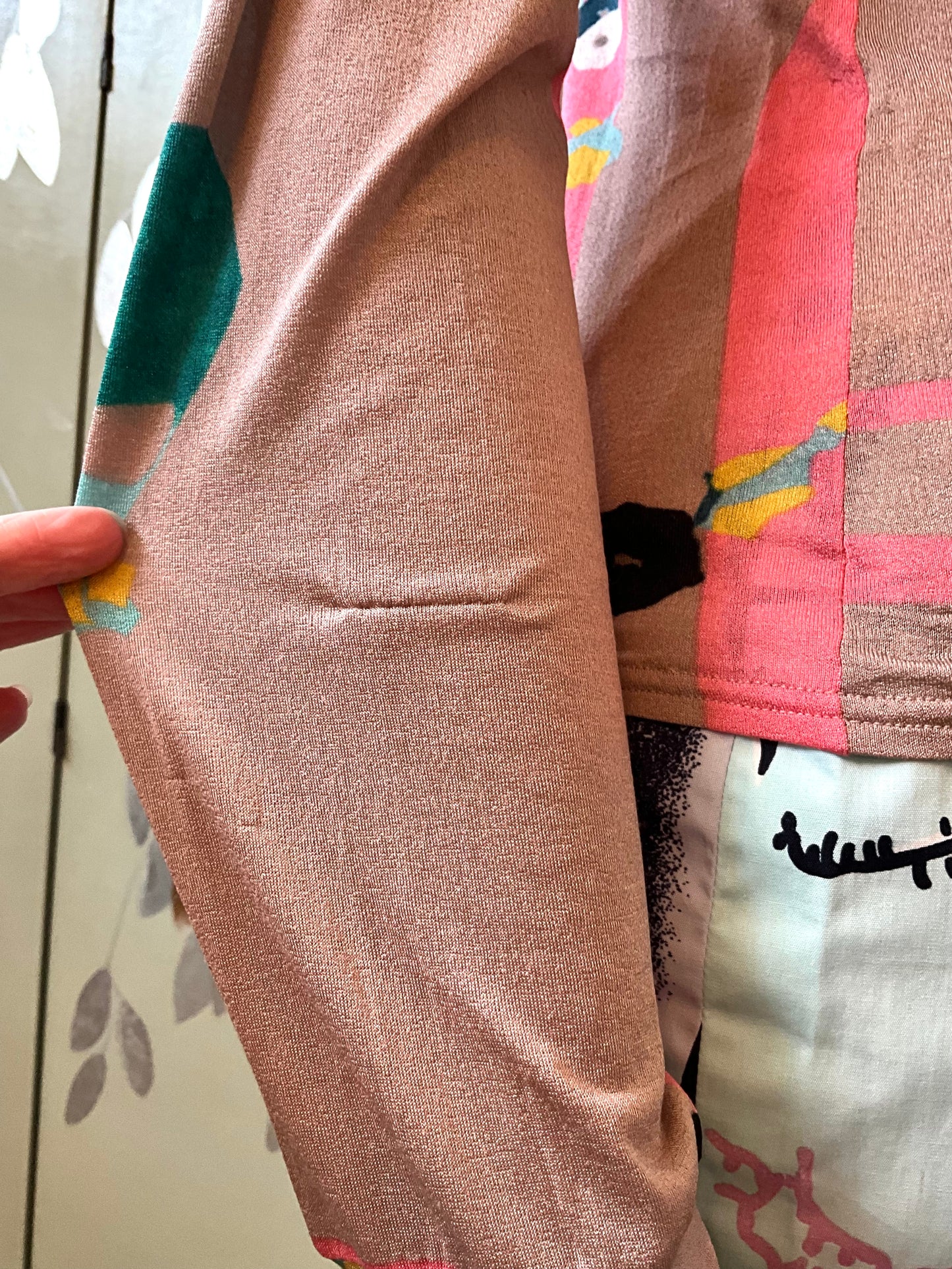 Close-up of a defect on the sleeve of a colorful top on a mannequin 