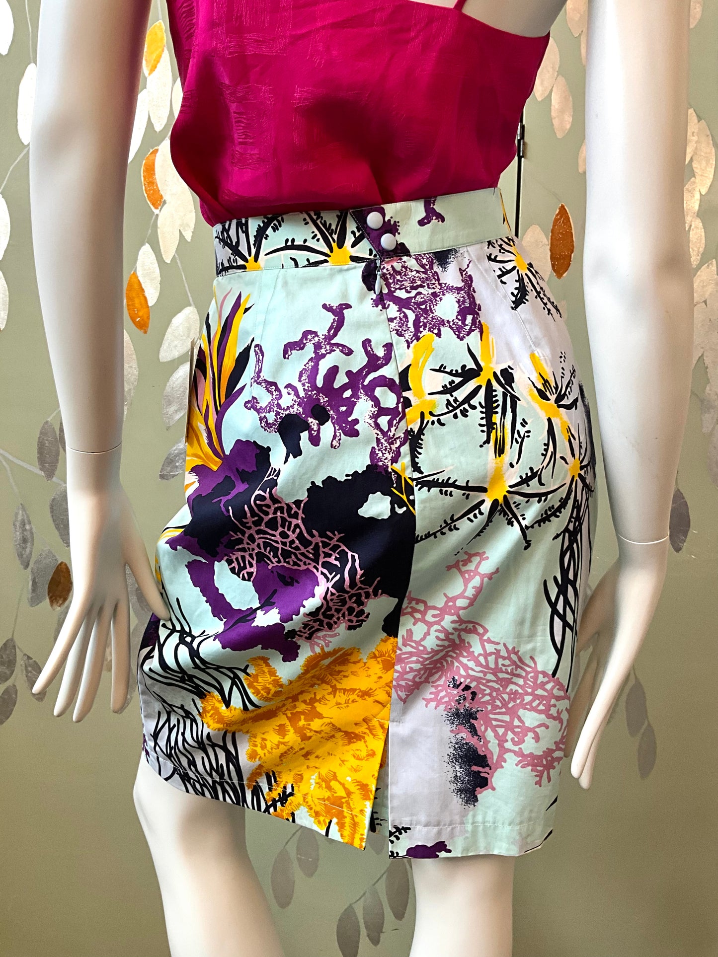 Mannequin wearing a colorful floral skirt with a pink top against a neutral background