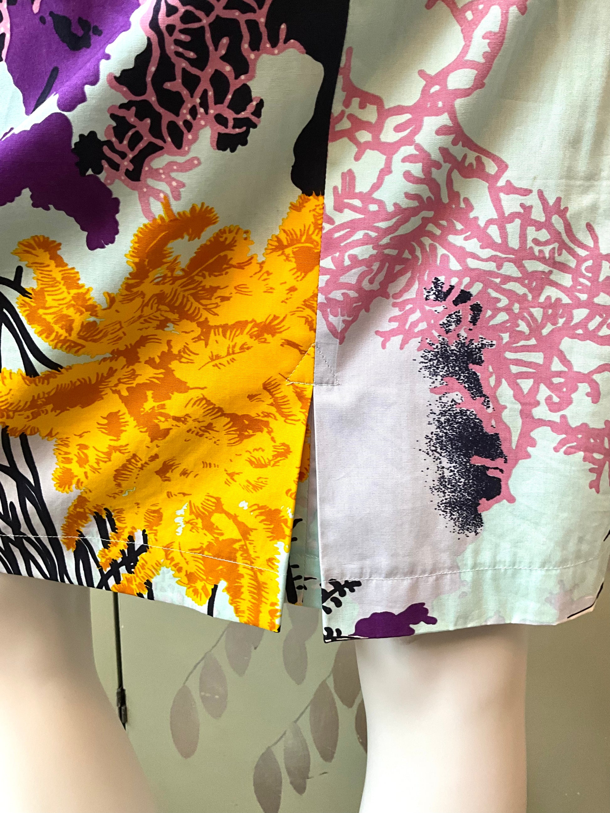 Close-up of a colorful fabric with floral and abstract patterns.