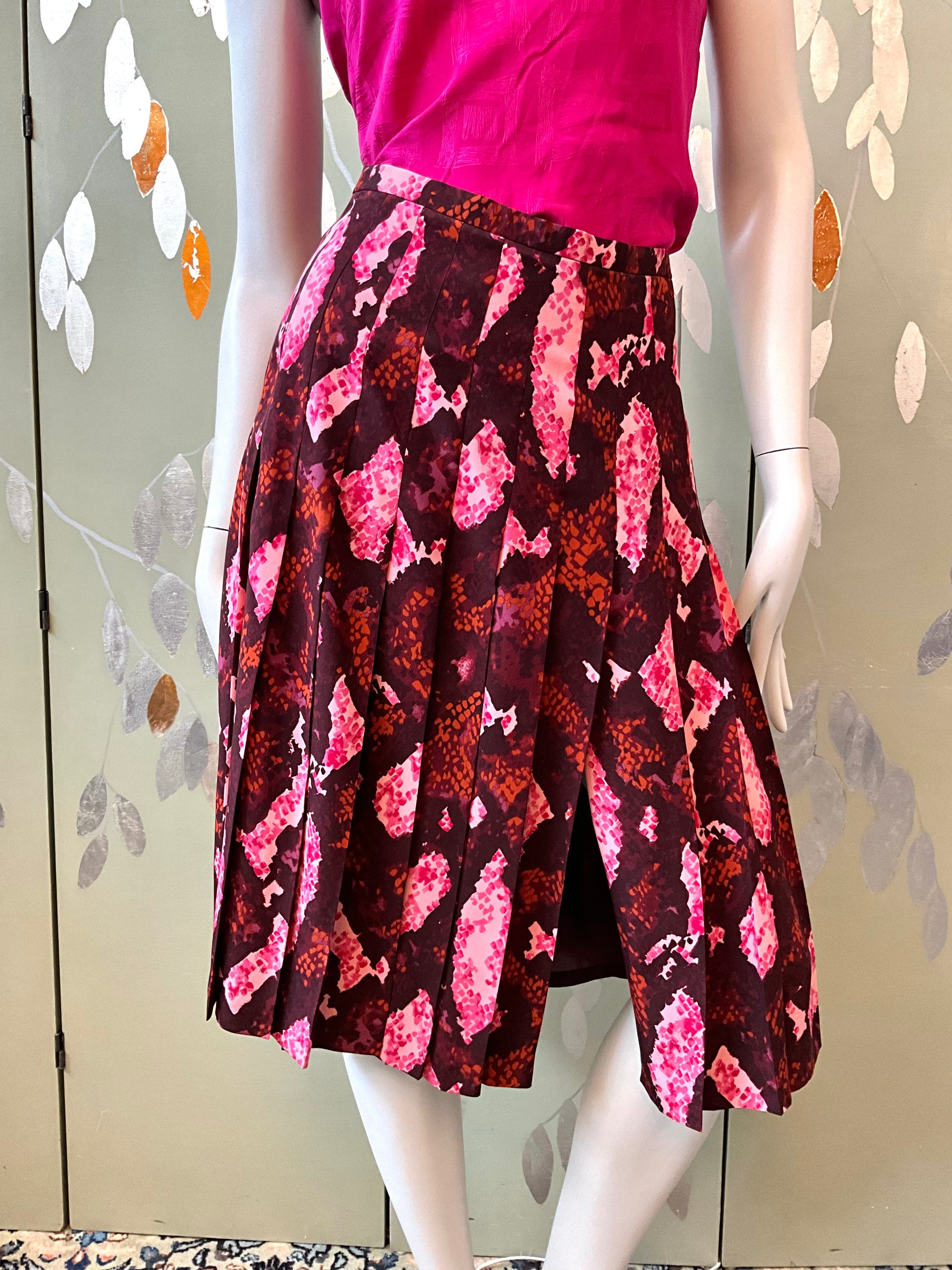 Mannequin wearing a pink top and patterned skirt against a neutral background