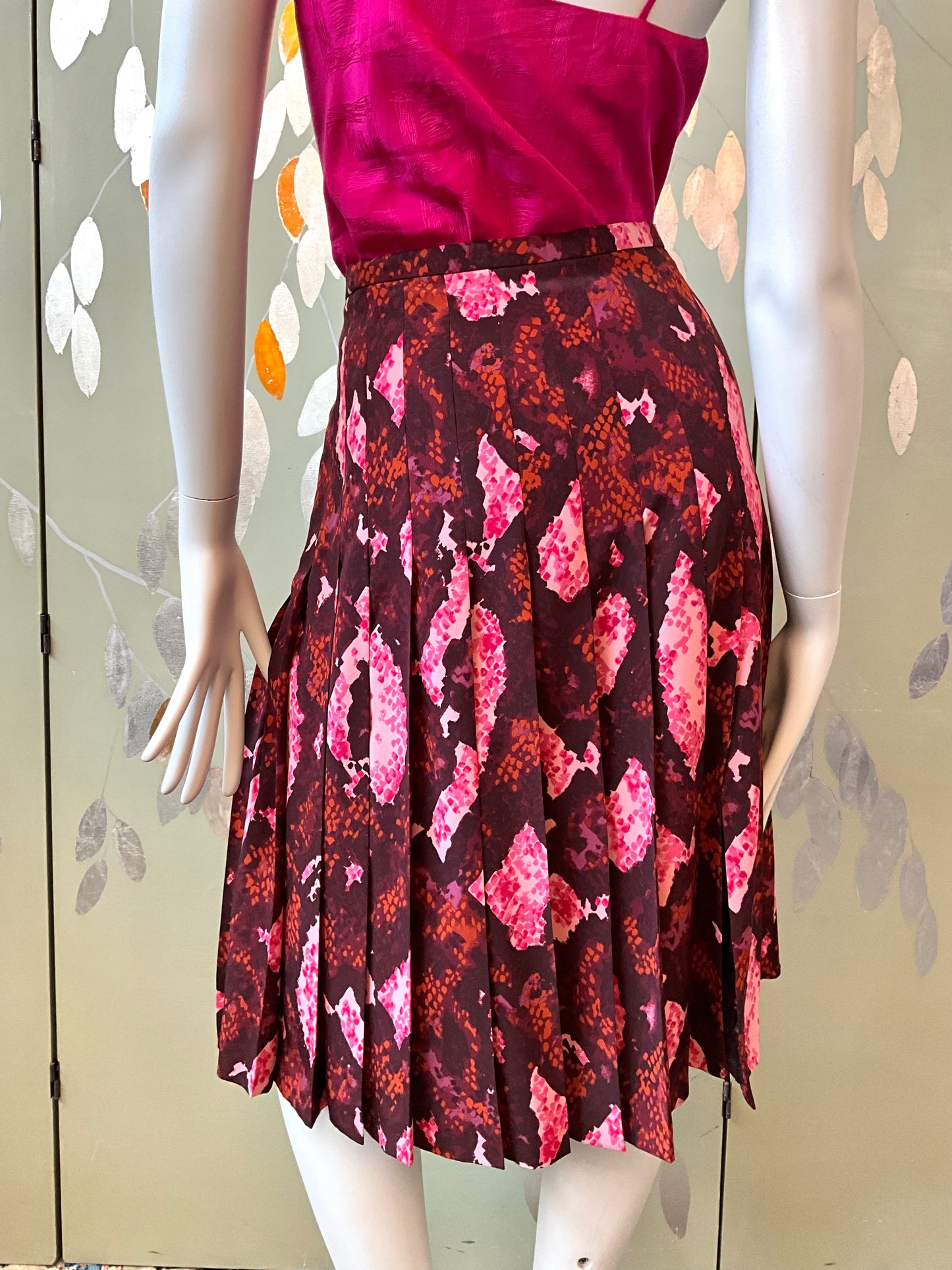 Mannequin wearing a pink top and patterned skirt against a light background