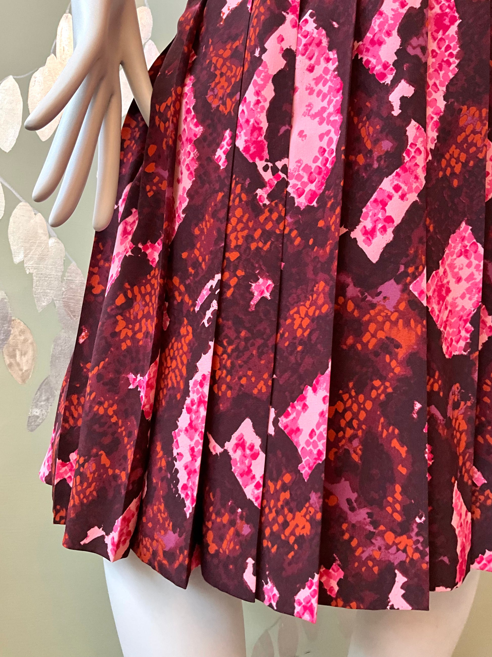 Skirt with pink and red pattern on a mannequin against a neutral background