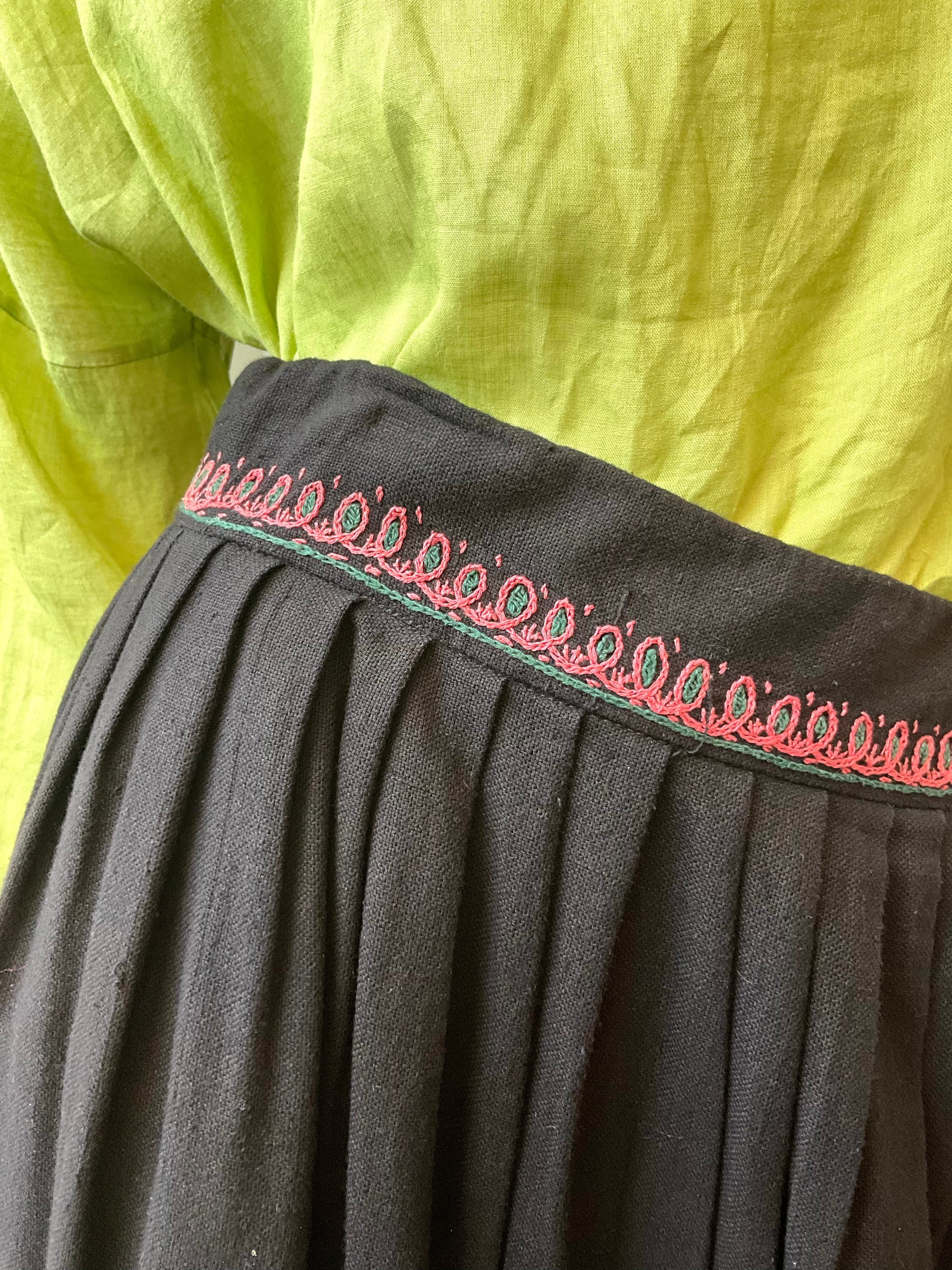 Black pleated fabric with red embroidery 