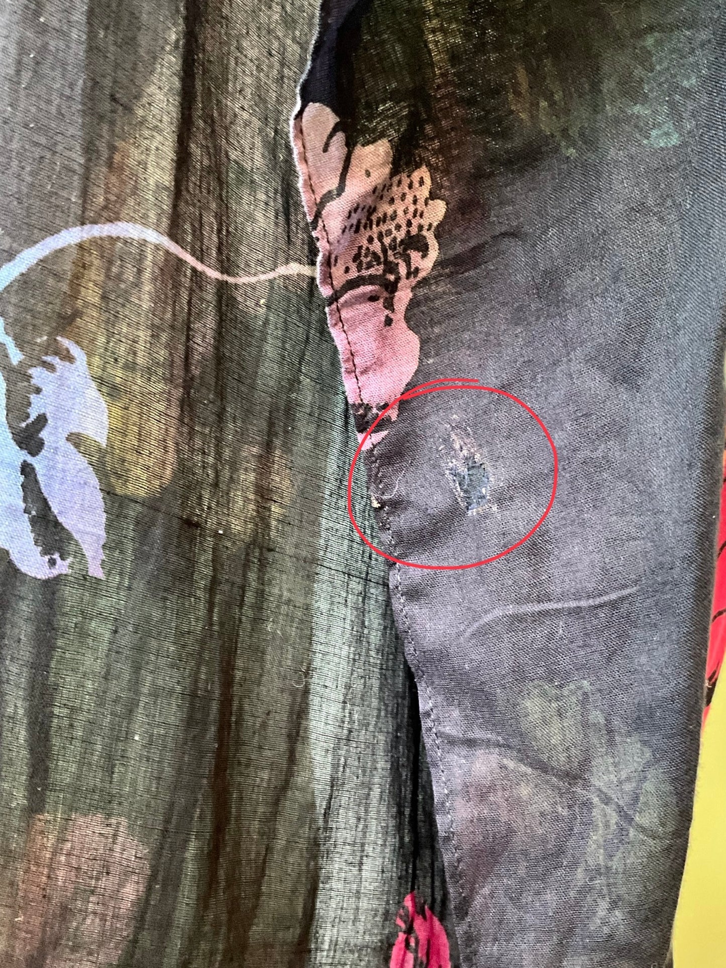 Close-up of a fabric with a red circle highlighting a small defect. 