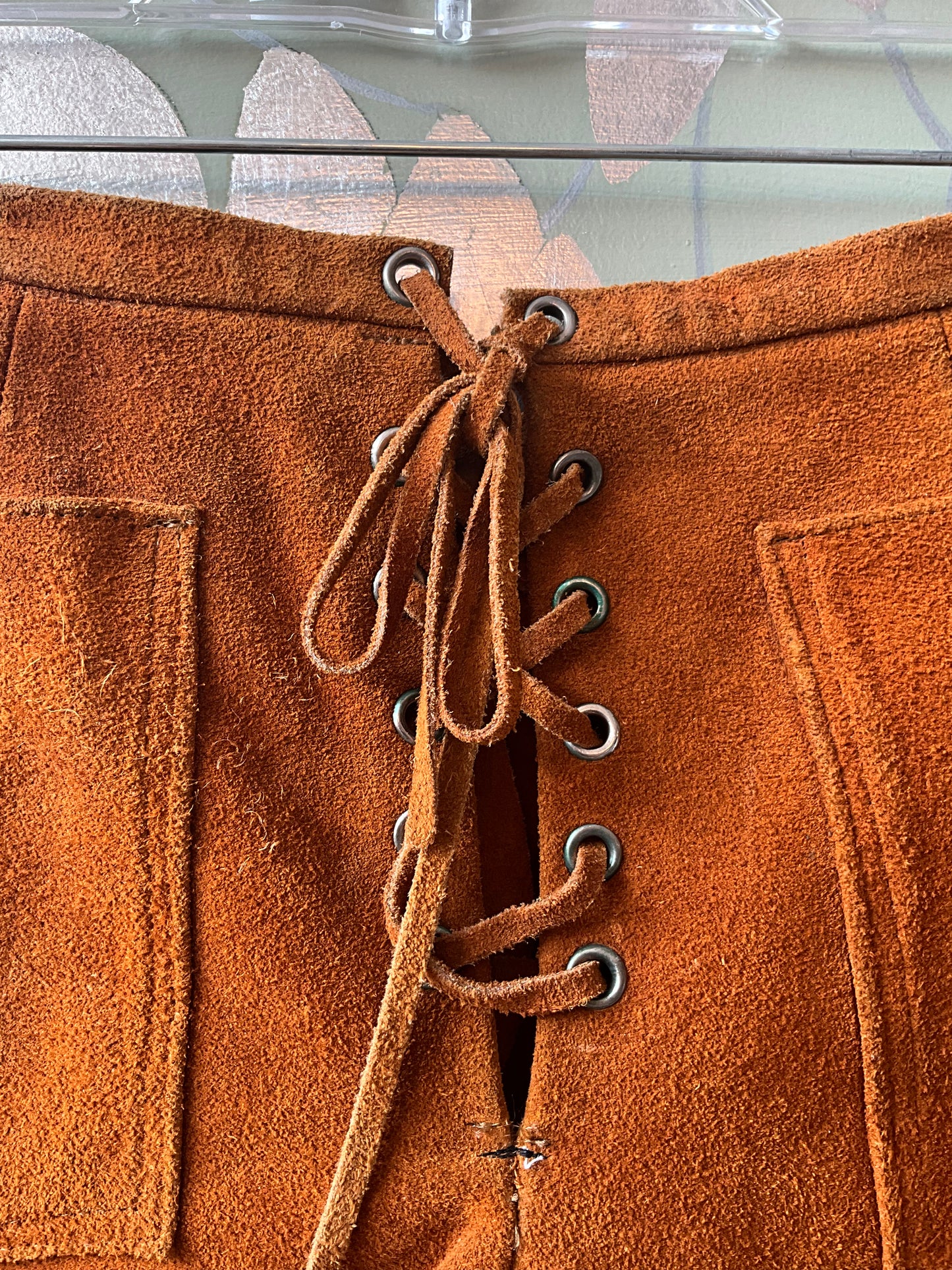 Close-up of brown suede shorts with laces 