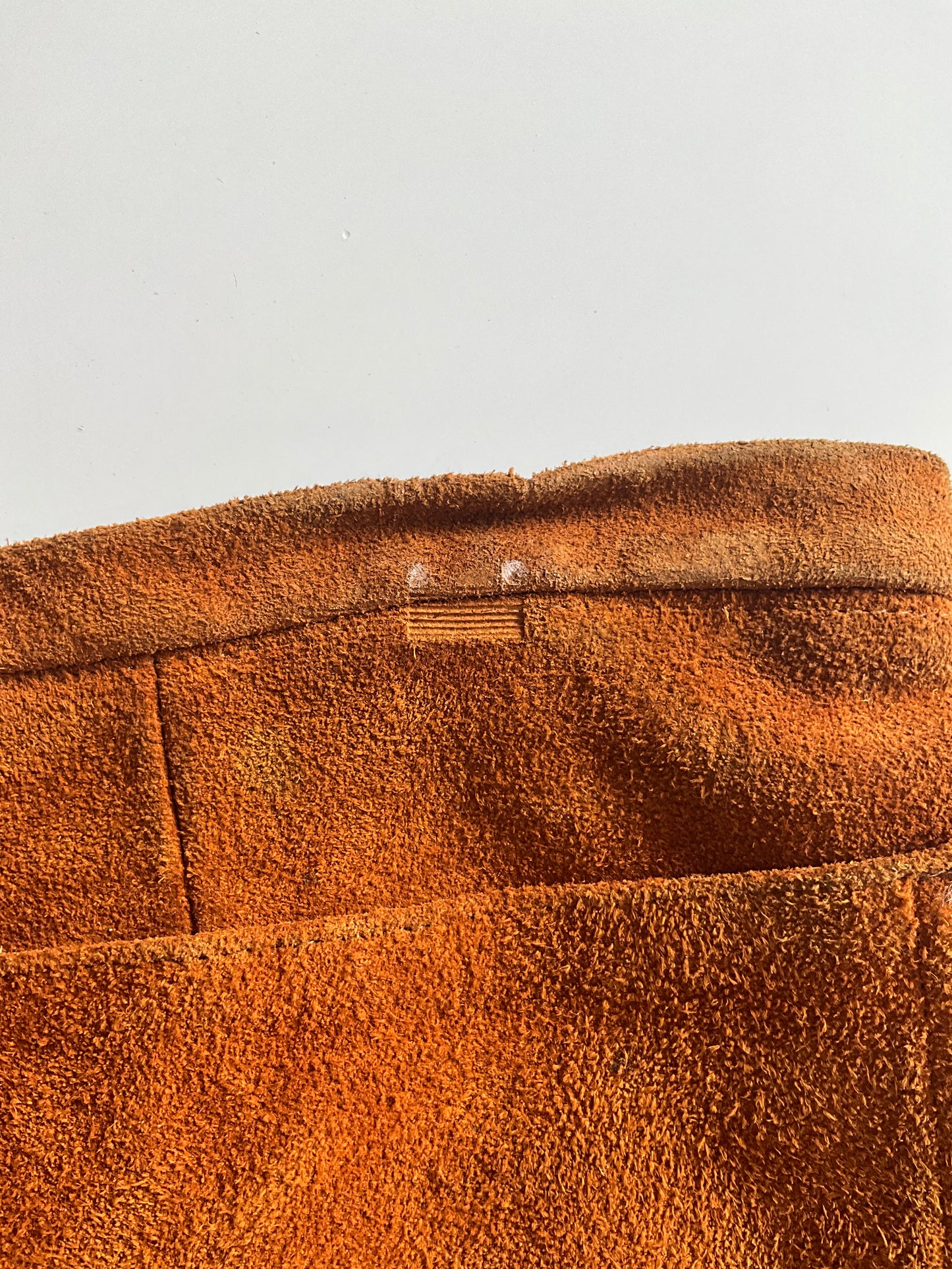 Close-up of brown suede waistband with a condition issue 
