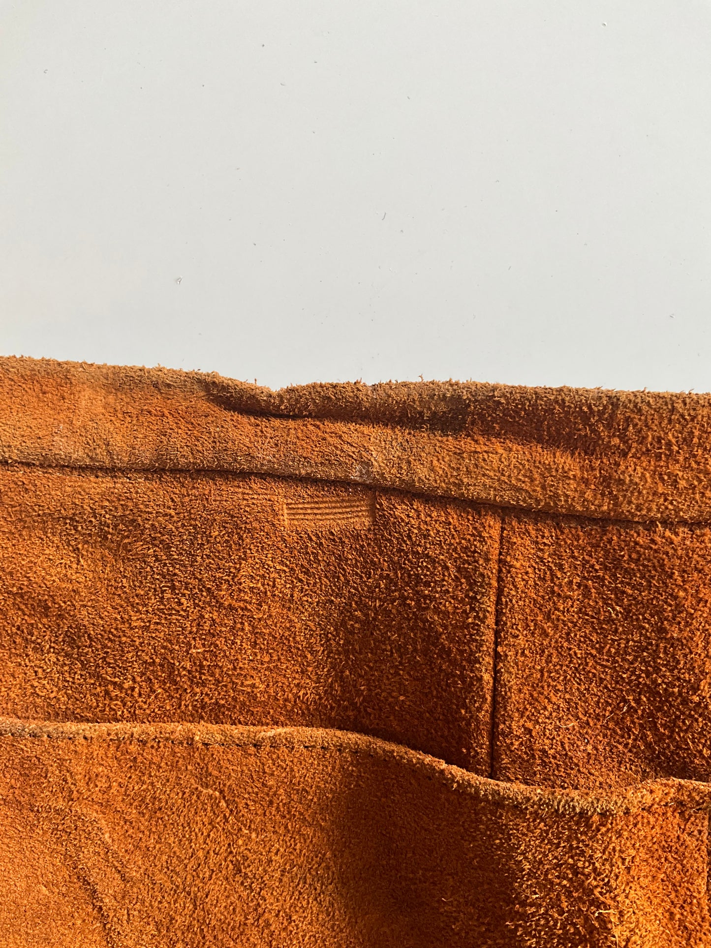 Close-up of brown suede waistband with a condition issue 
