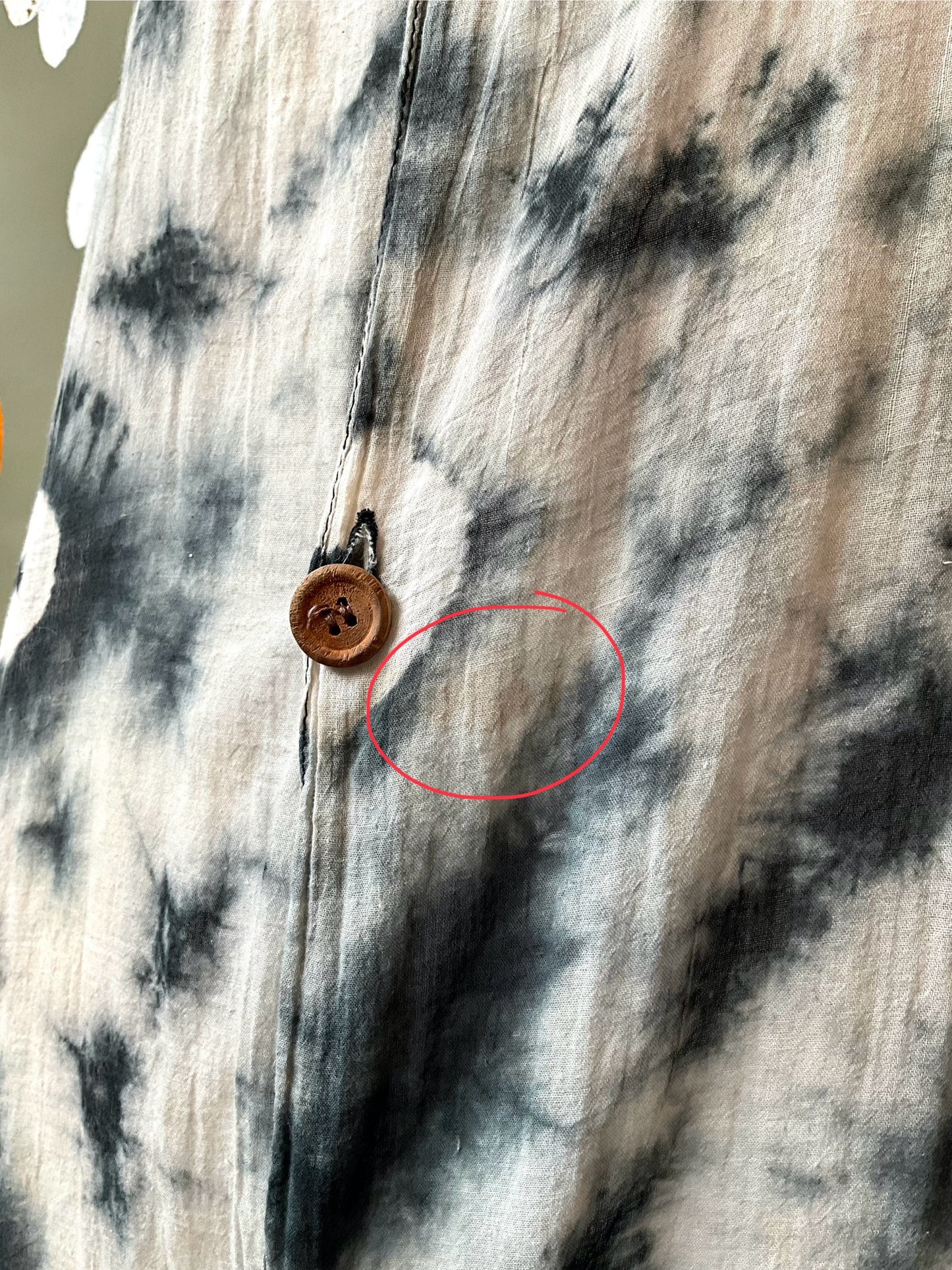 Close-up of a tie-dye shirt with a wooden button