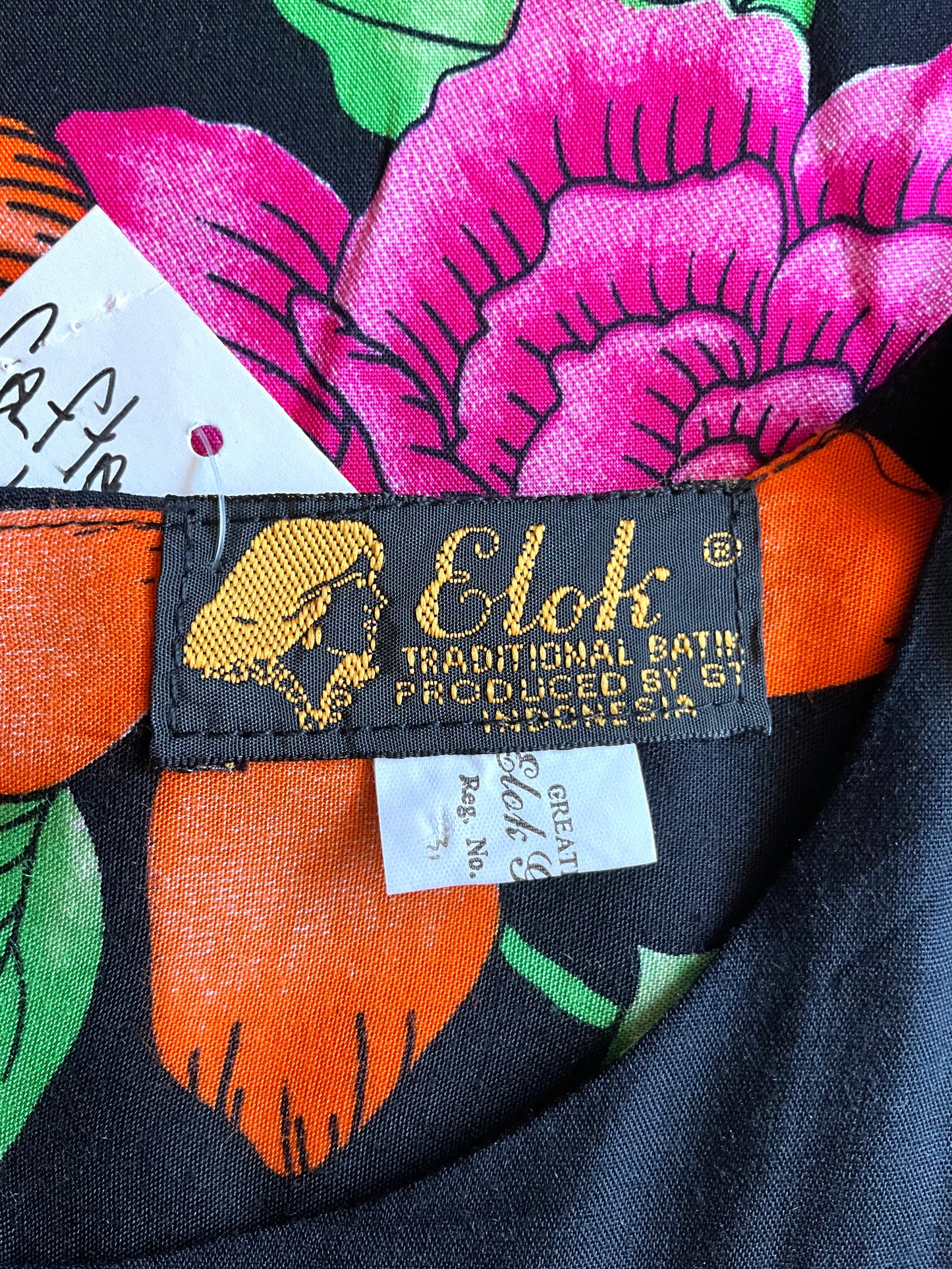 Fabric with a colorful floral pattern and 'Elok' label on a black background