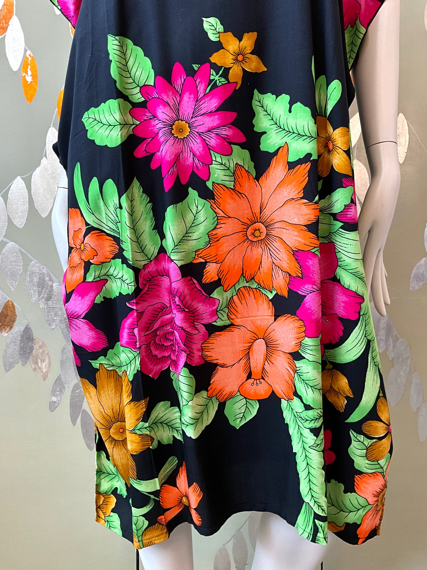 Mannequin wearing a black dress with colorful floral pattern