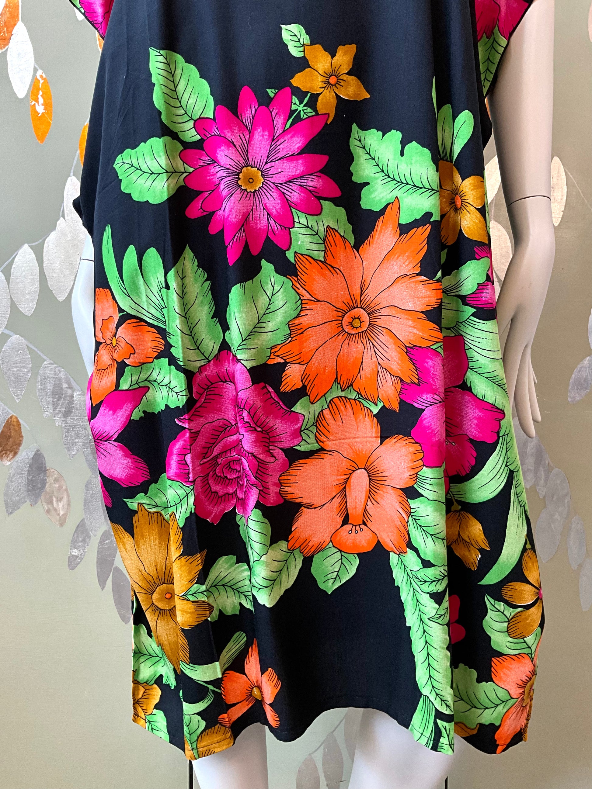 Mannequin wearing a black dress with colorful floral pattern
