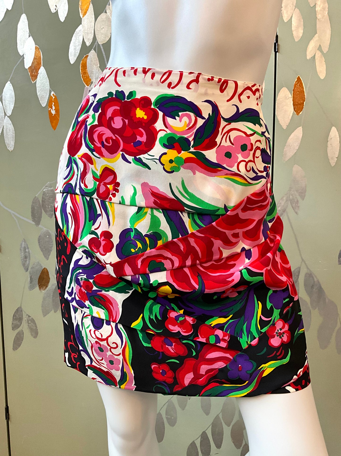 Colorful floral skirt on a mannequin against a patterned background
