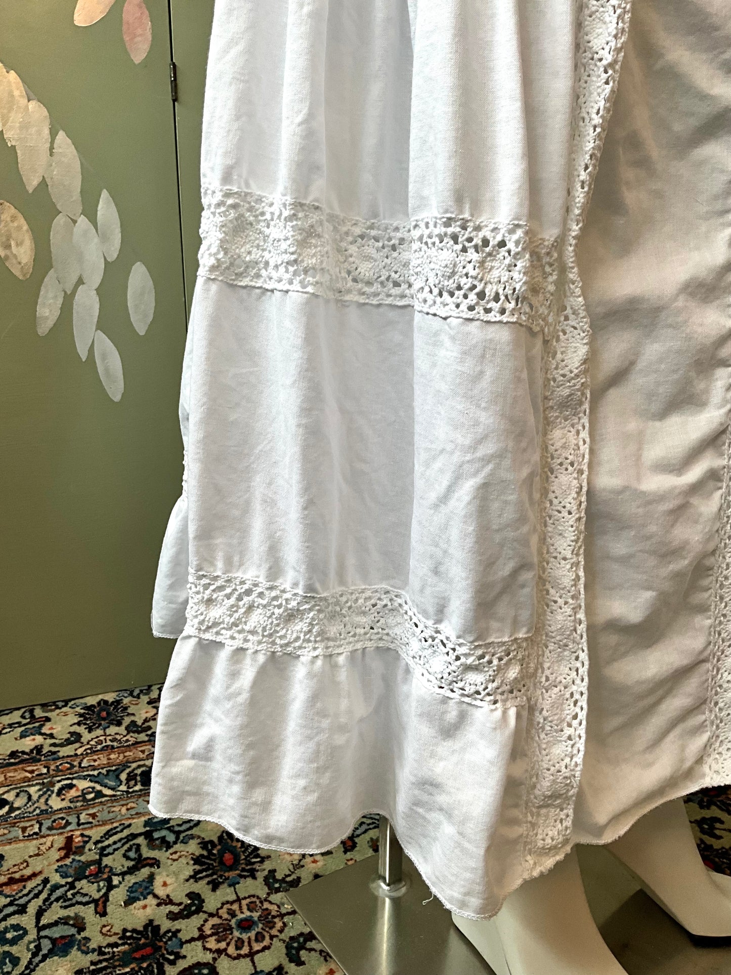 White skirt with lace details on a mannequin against a neutral background