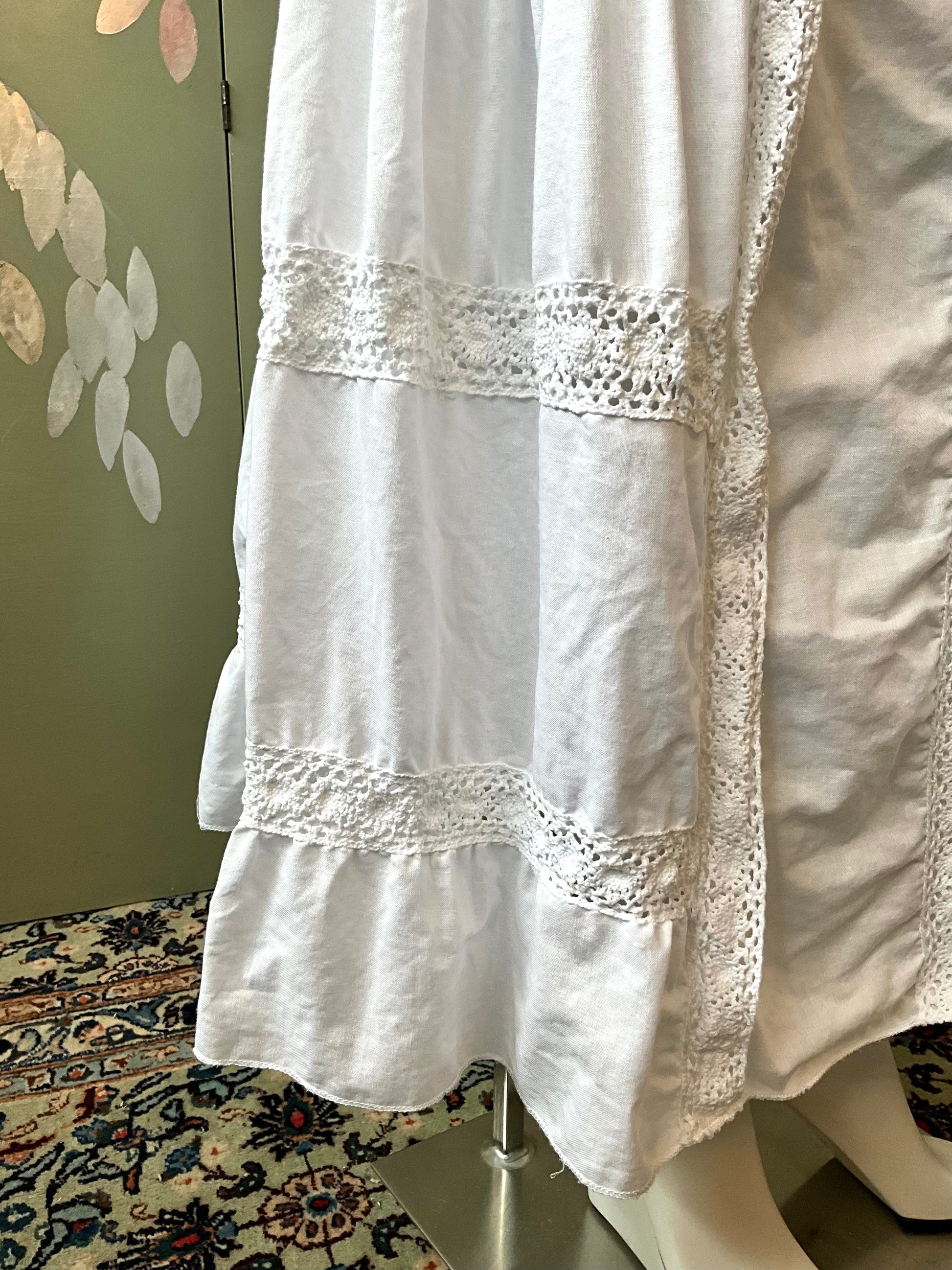 White skirt with lace details on a mannequin against a neutral background
