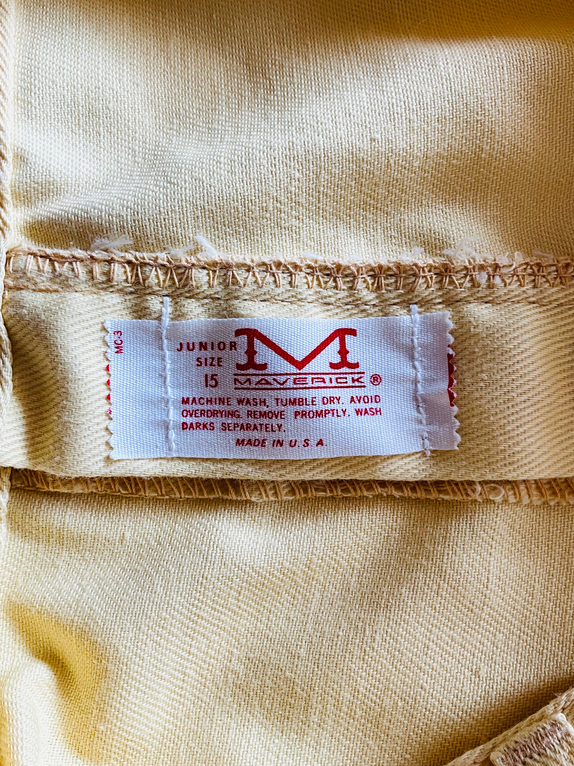 Close-up of a label on yellow fabric with 'Maverick' branding.