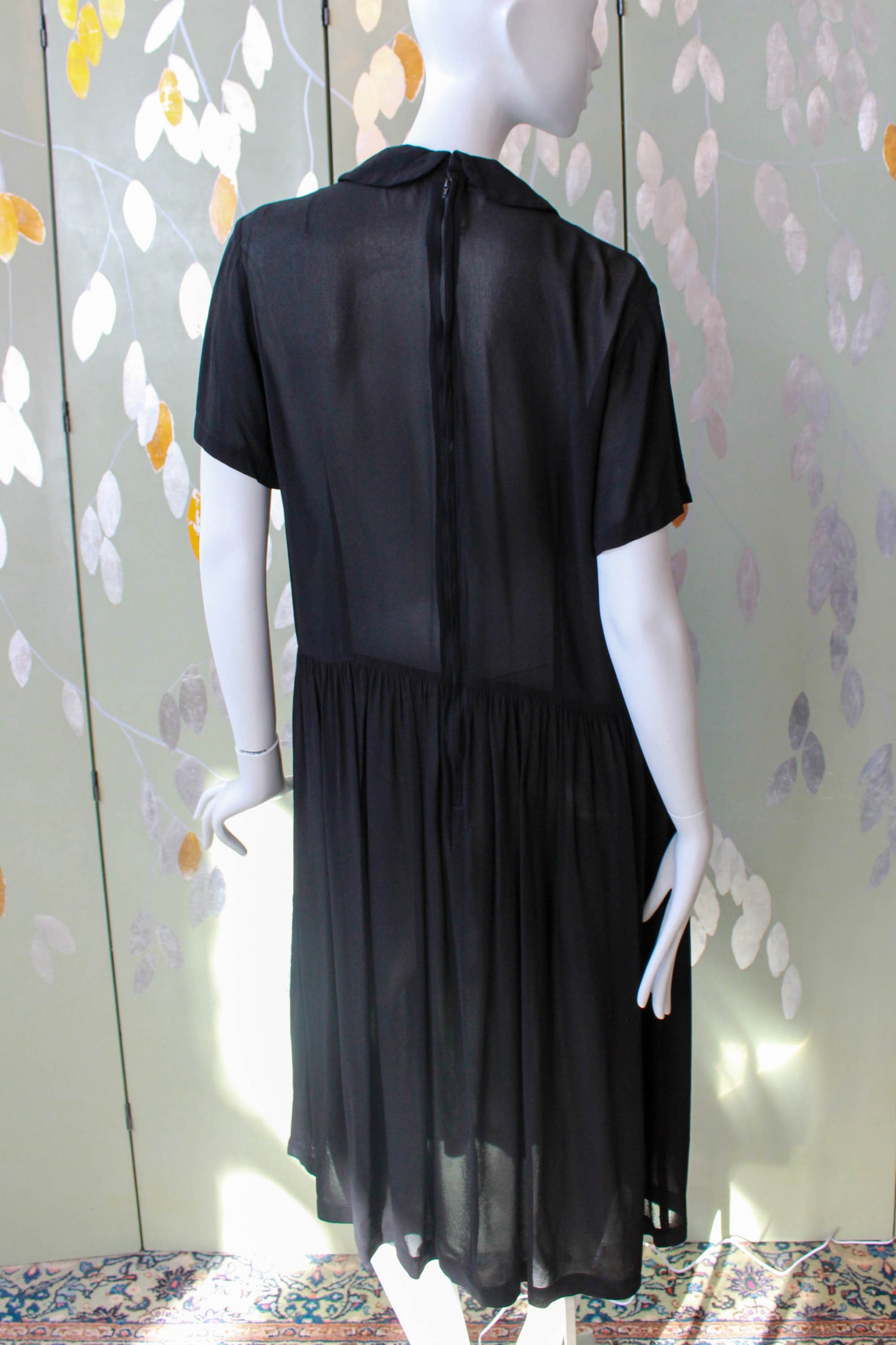 comme des garcons sheer black dress with peterpan collar, gathered skirt, short sleeves, pleated know detail on front, midi length