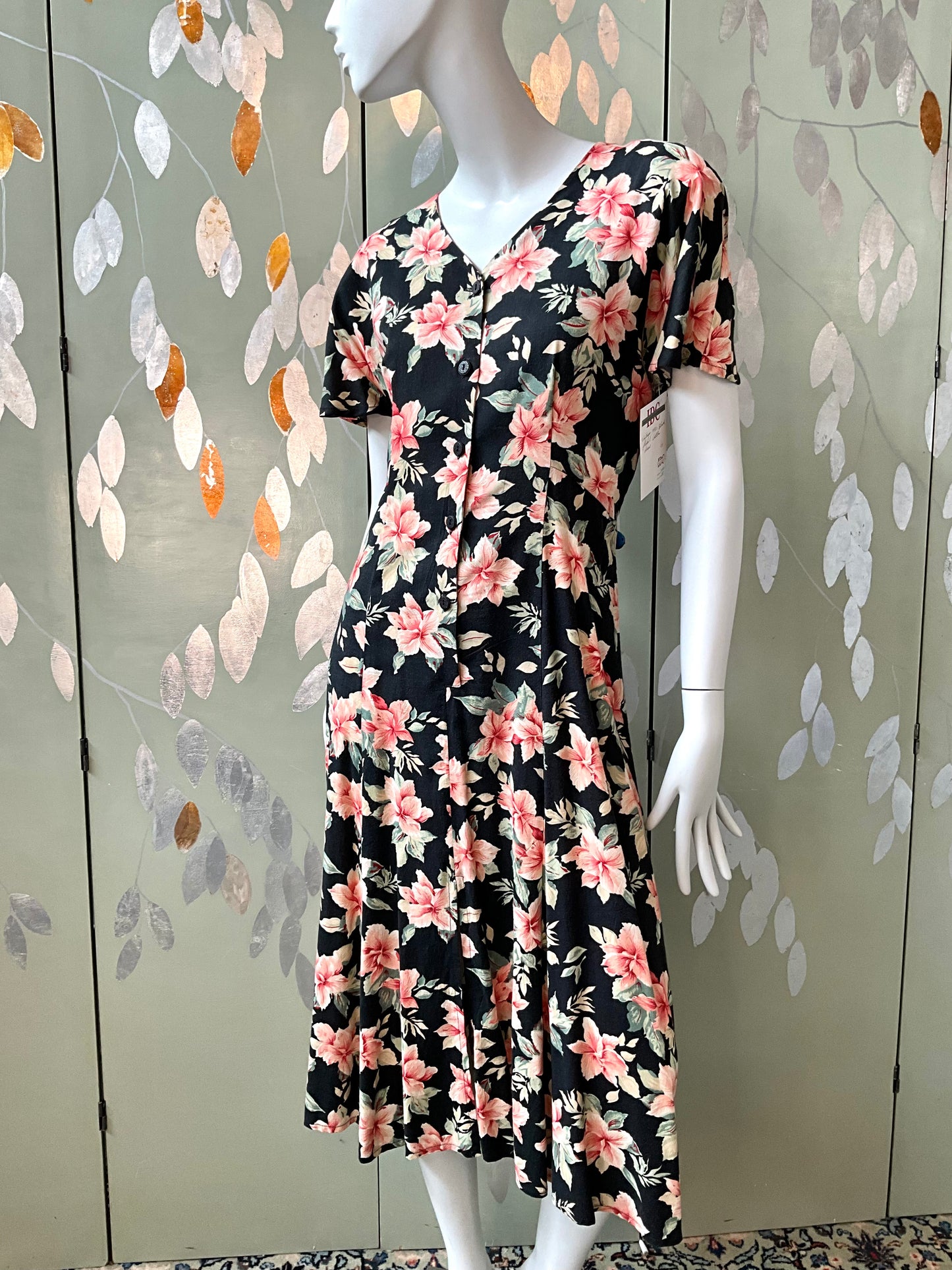 Mannequin wearing a floral dress with a decorative background