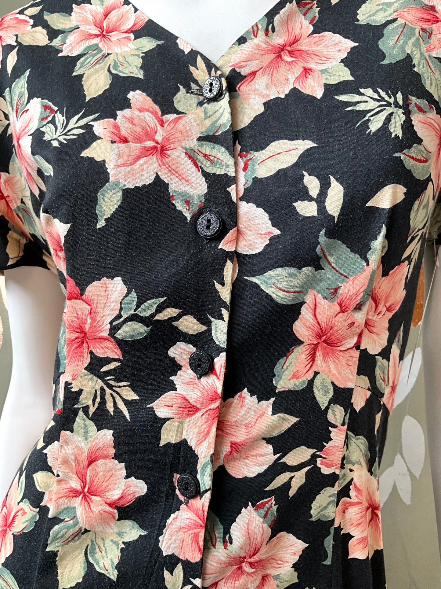 Close-up of a floral patterned dress with pink flowers on a black background