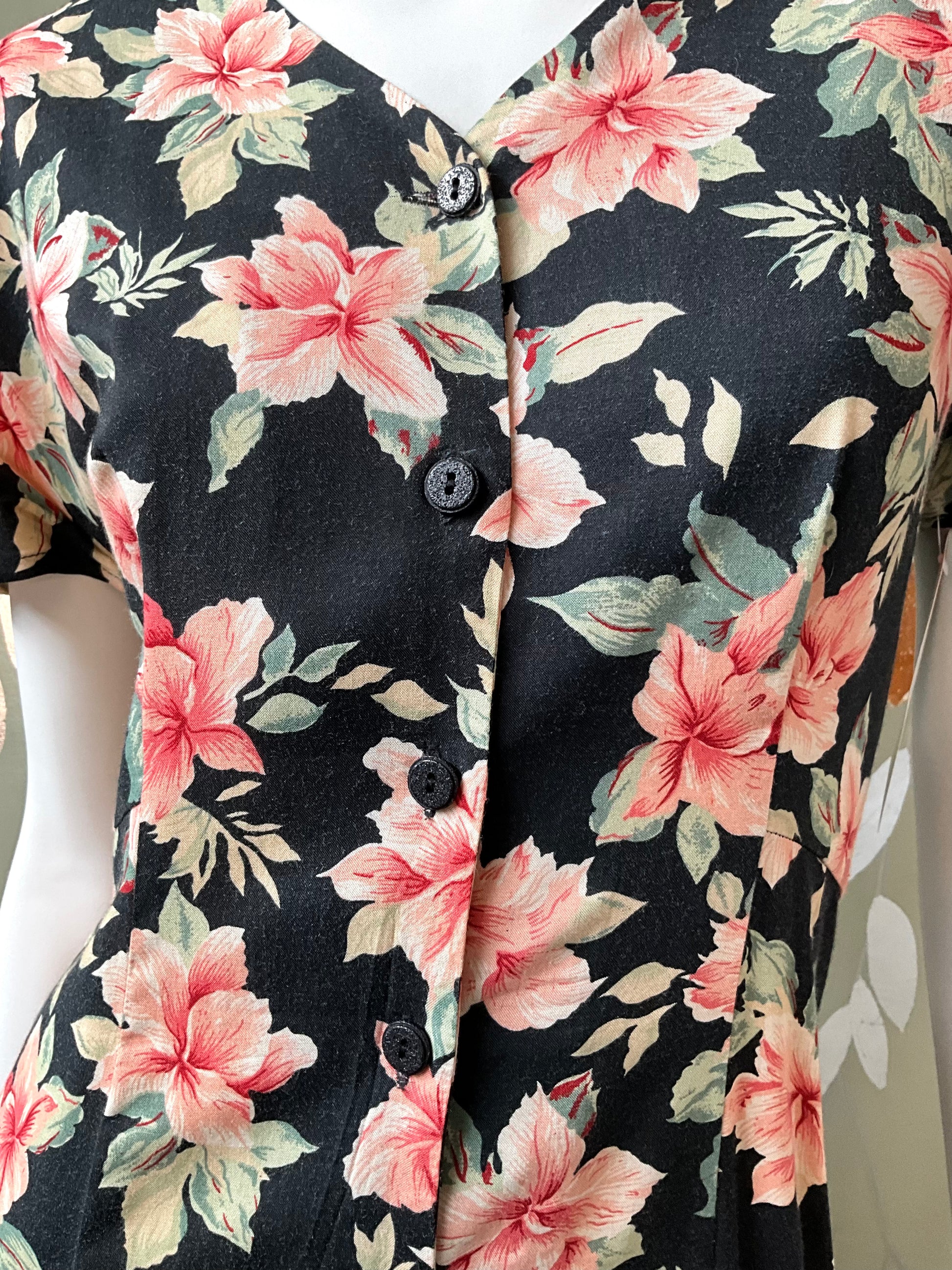 Close-up of a floral patterned dress with pink flowers on a black background