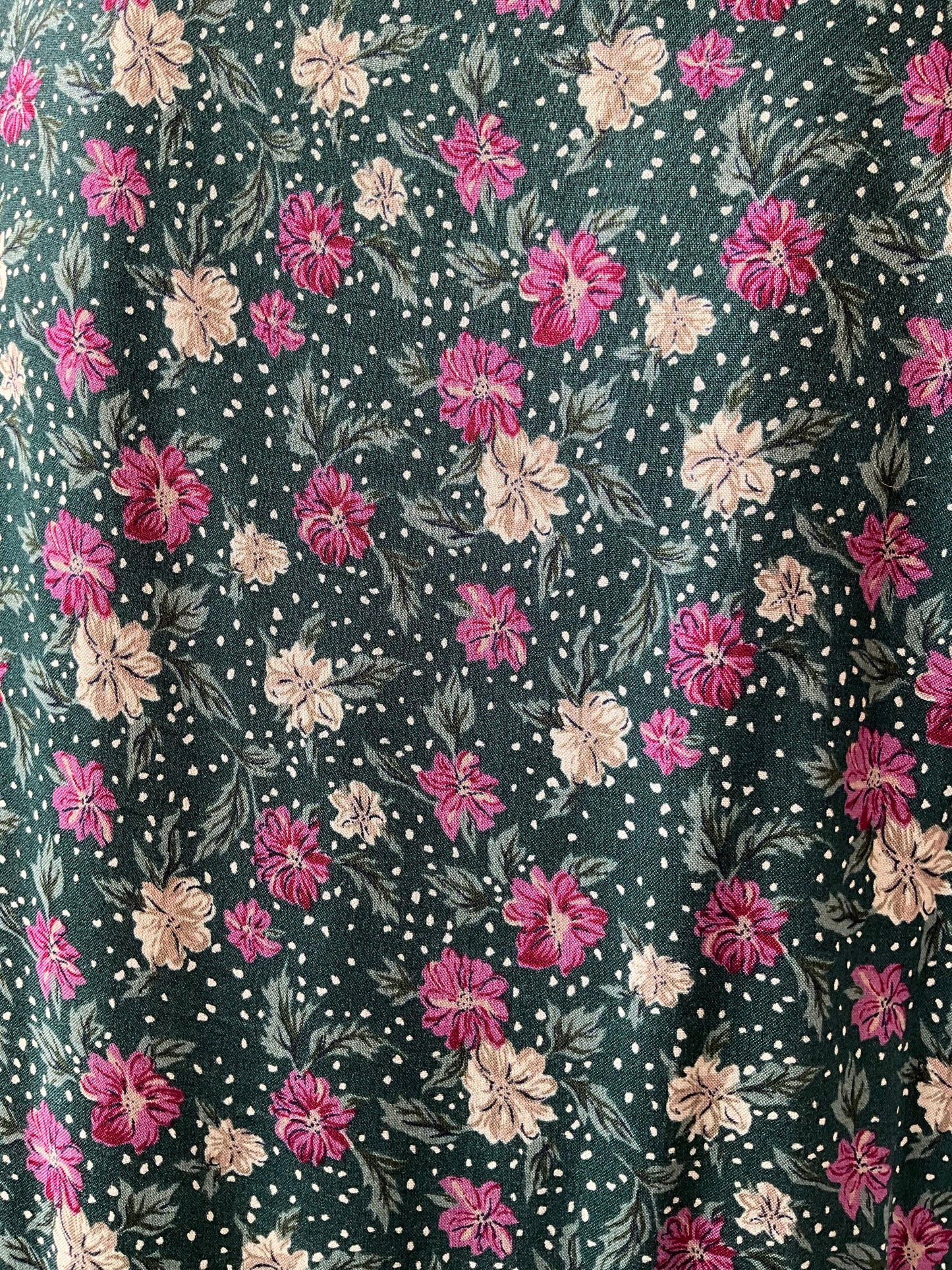 Floral pattern with pink and beige flowers on a dark green background