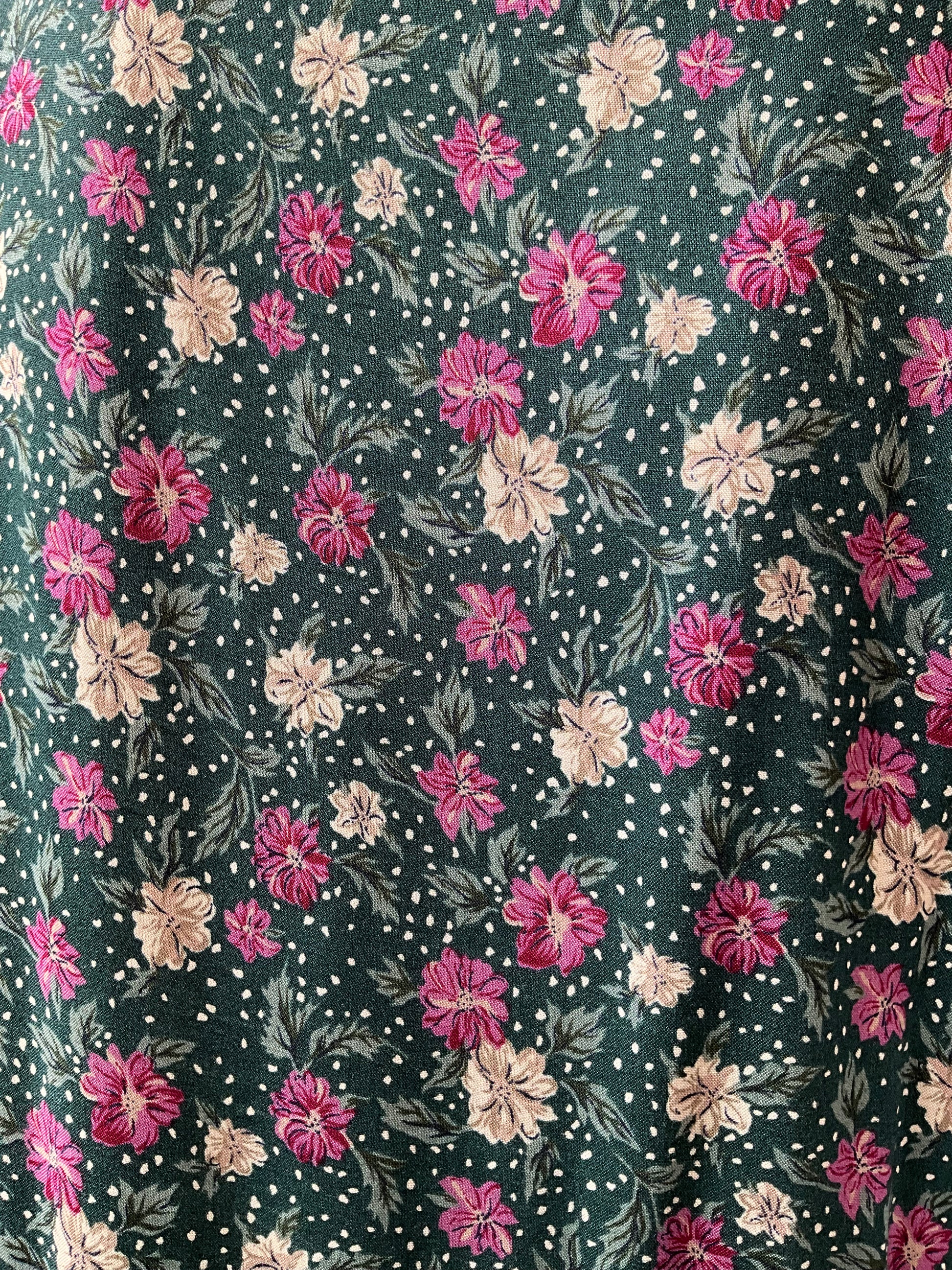 Floral pattern with pink and beige flowers on a dark green background