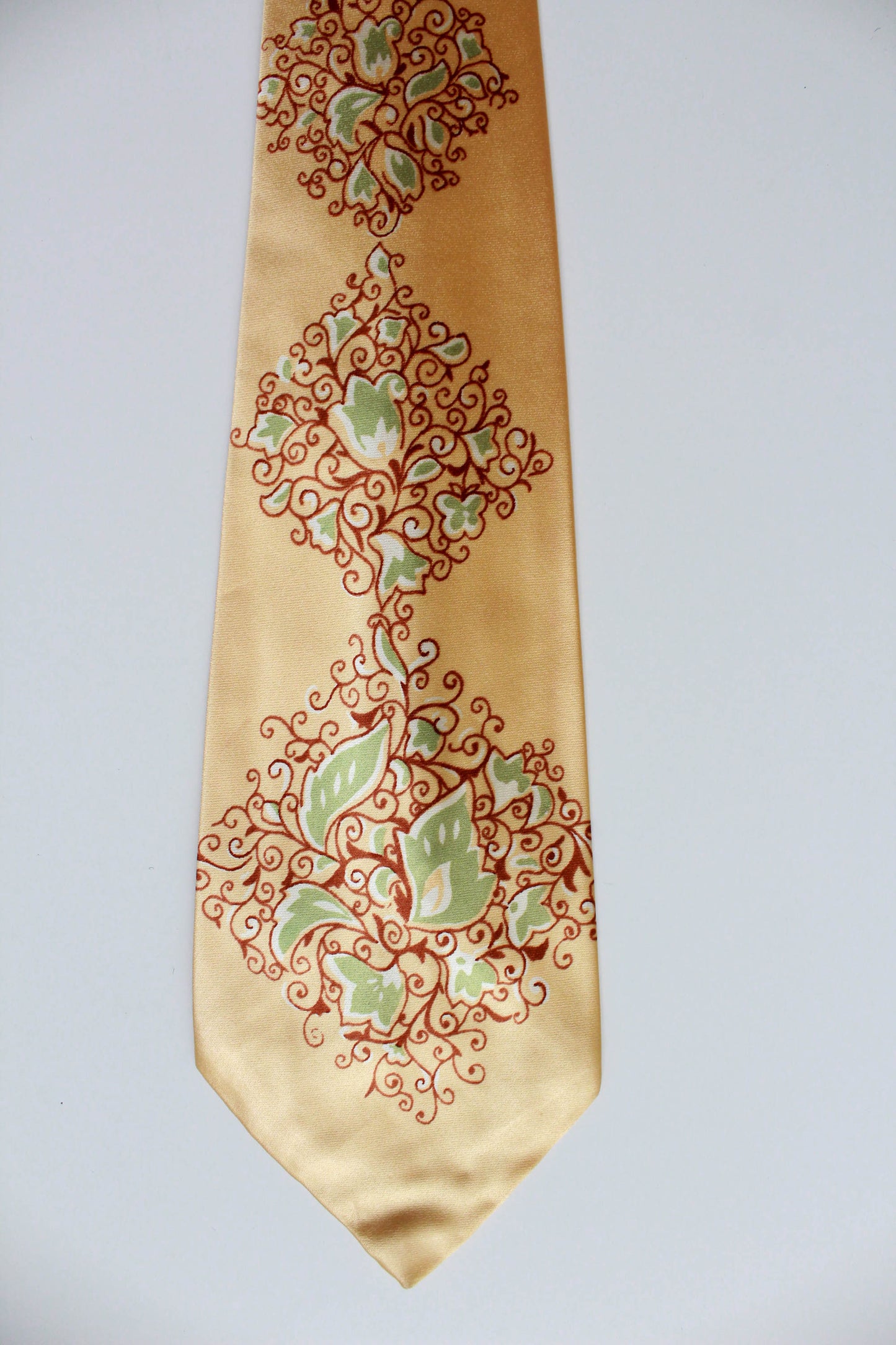 1940s yellow rayon necktie with wide tongue by Arrow. Brown and green ornate scrolling floral print design. vintage bold look necktie