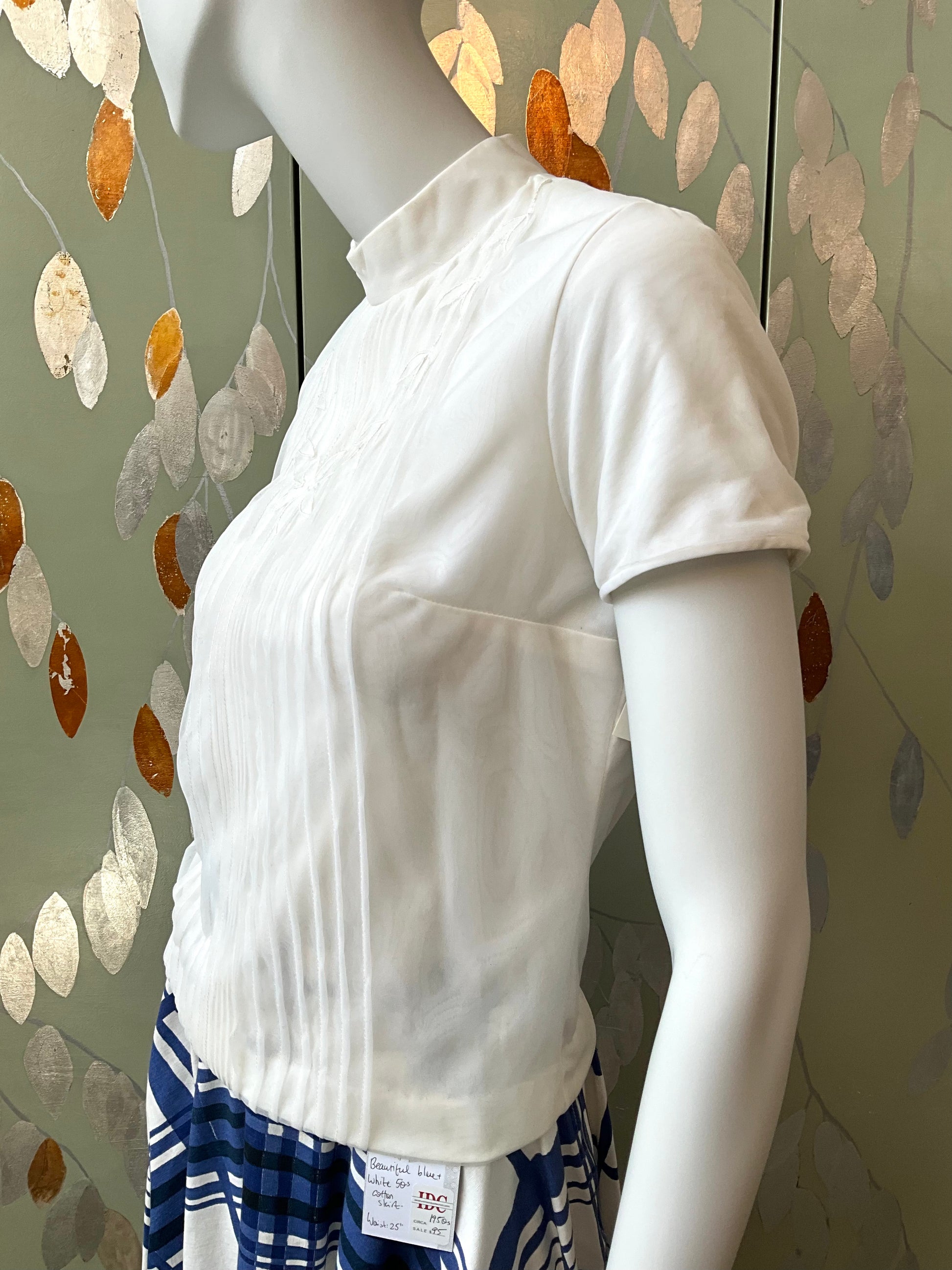 White shirt on a mannequin with a patterned background