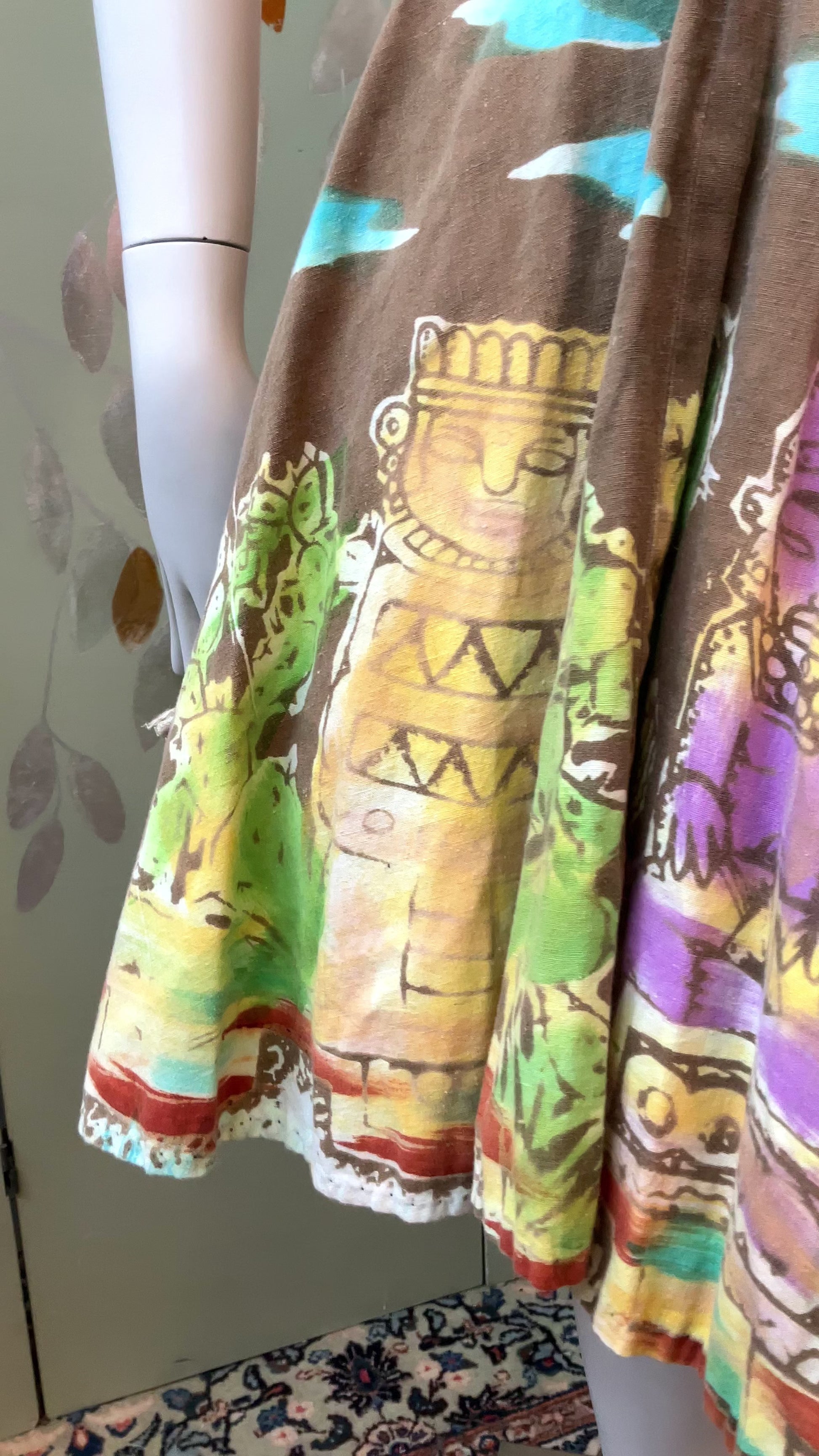 Close up of a 1950s Mexican Circle Skirt  showing print with dancing ladies and indigenous tribal statues 