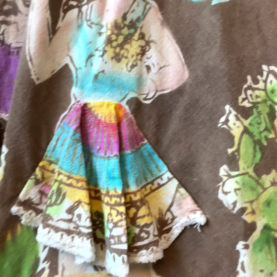 Close up of a 1950s Mexican Circle Skirt  showing print with dancing ladies and indigenous tribal statues 