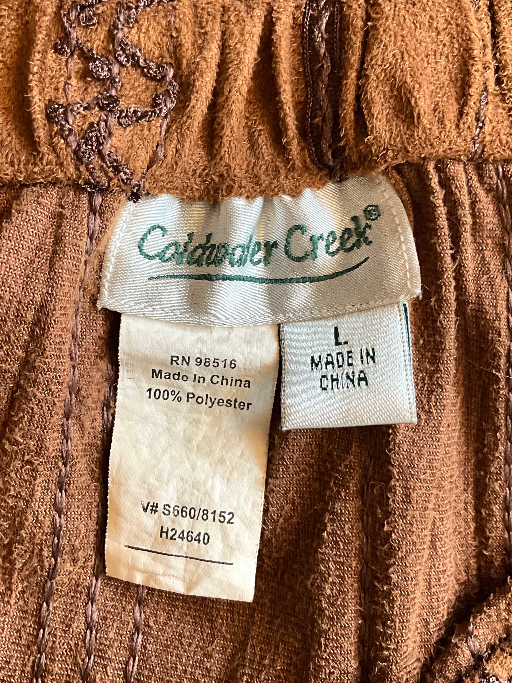 Close-up of a label on a brown textured fabric with 'Coldwater Creek' branding.