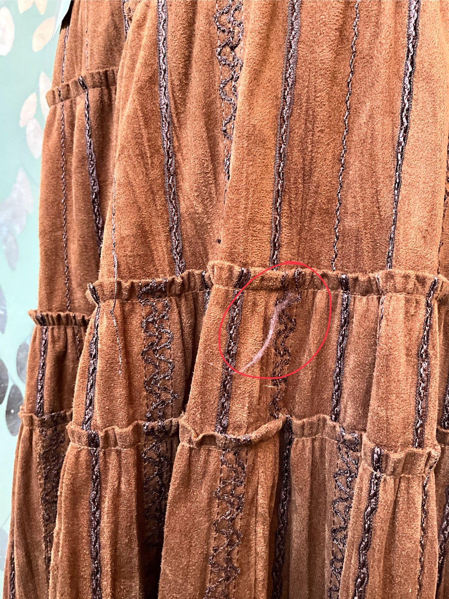 Brown textured fabric with a red circle highlighting a defect.