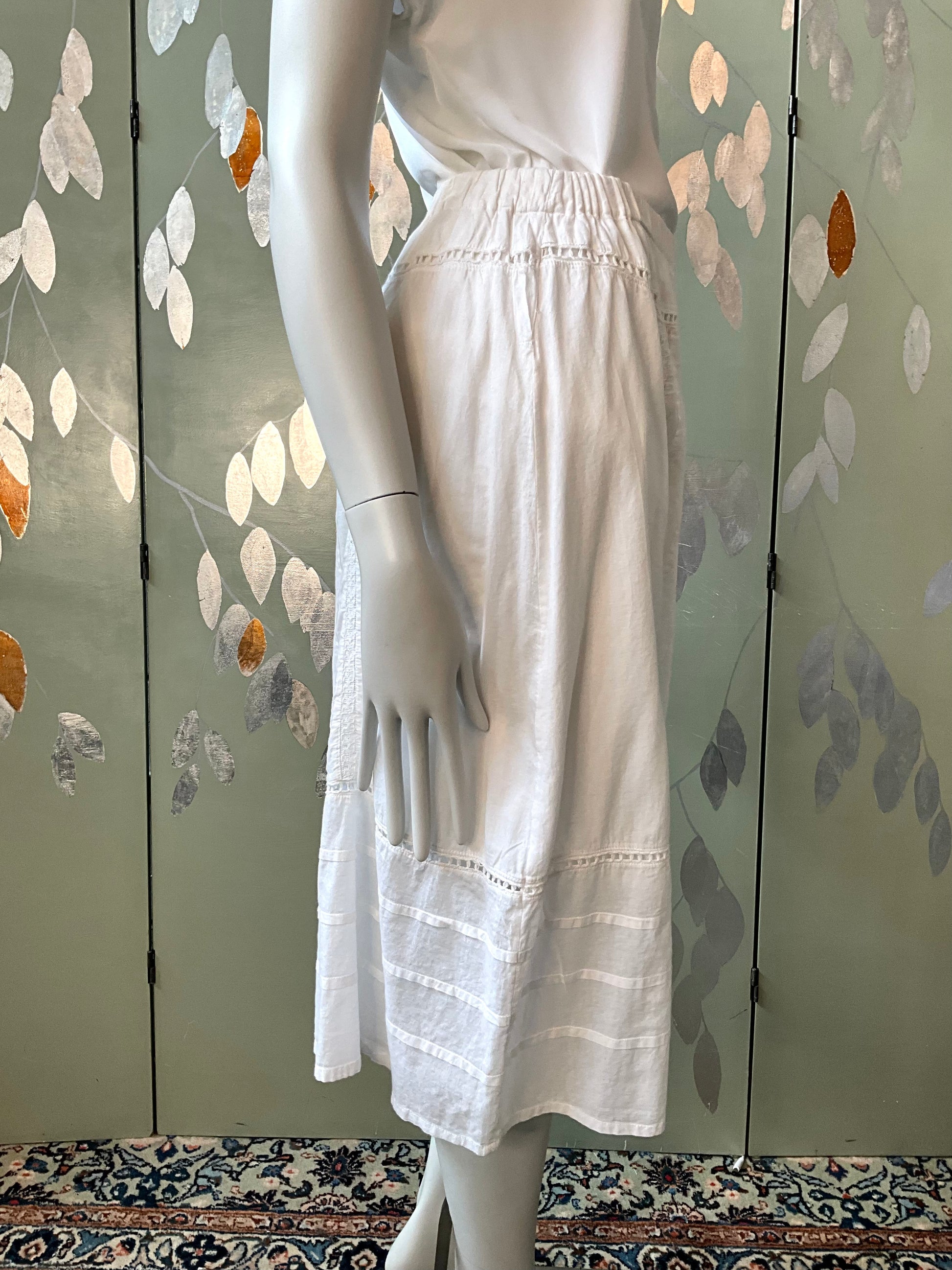 Mannequin wearing a white skirt with a floral-patterned background