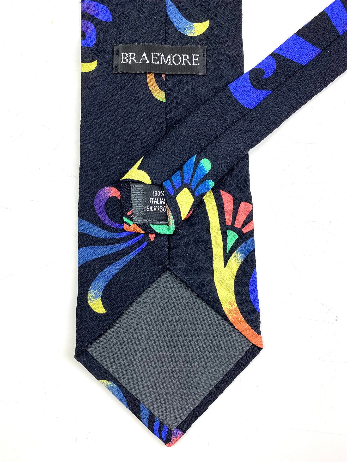 Back and labels of: 90s Deadstock Silk Necktie, Men's Vintage Purple/ Yellow/ Pink Tikki Pattern Tie, NOS