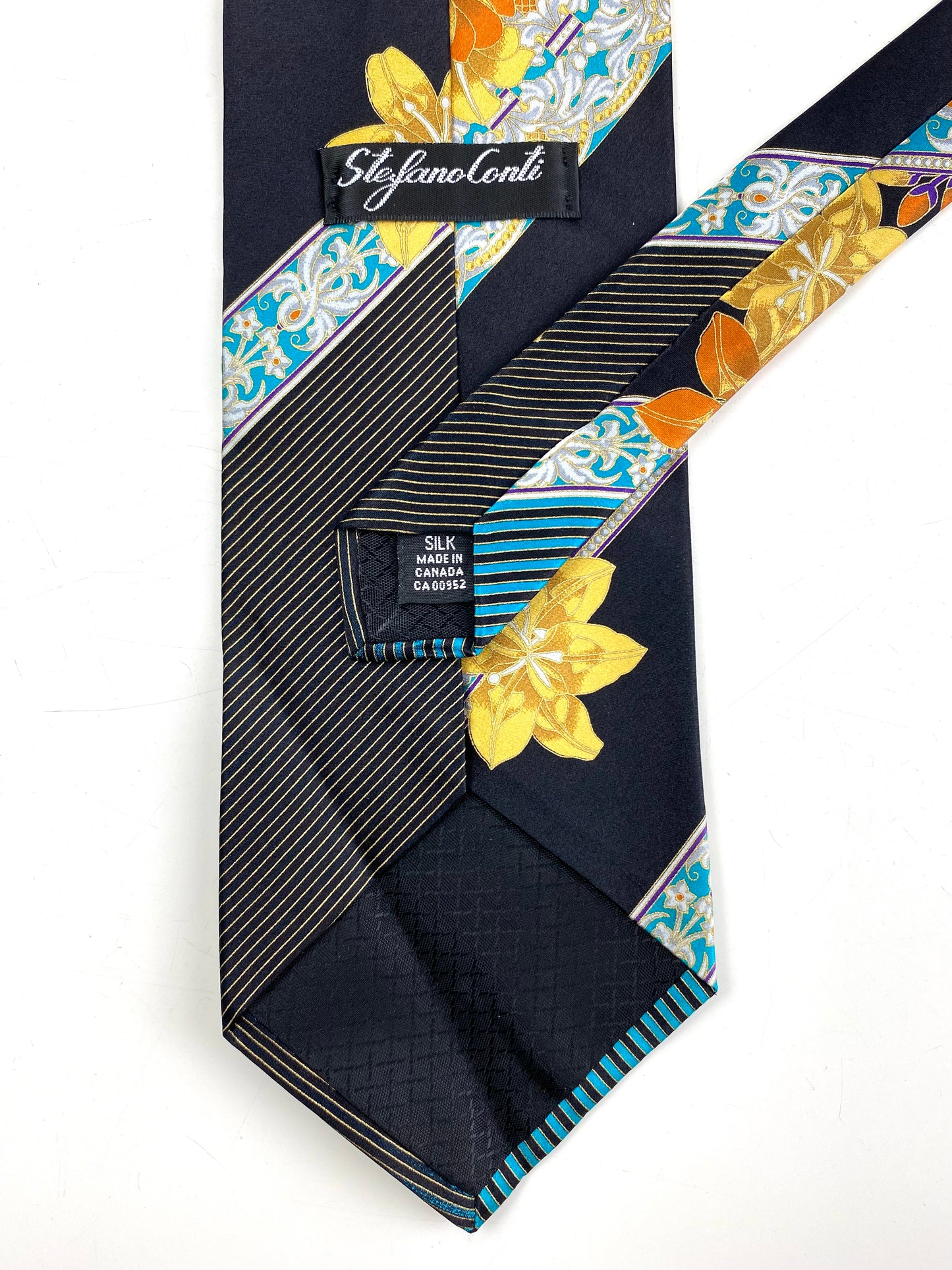Back and labels of: 90s Deadstock Silk Necktie, Men's Vintage  Black/ Gold/ Turquoise Floral Pattern Tie, NOS